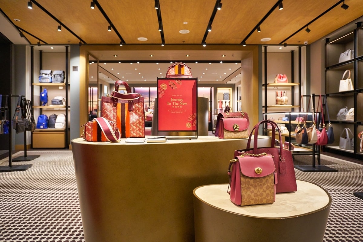 The interior of a Coach boutique showcasing the brand’s latest collection, featuring Signature canvas and leather bags in pink and red tones — a visual reminder of the label’s blend of craftsmanship and modern design