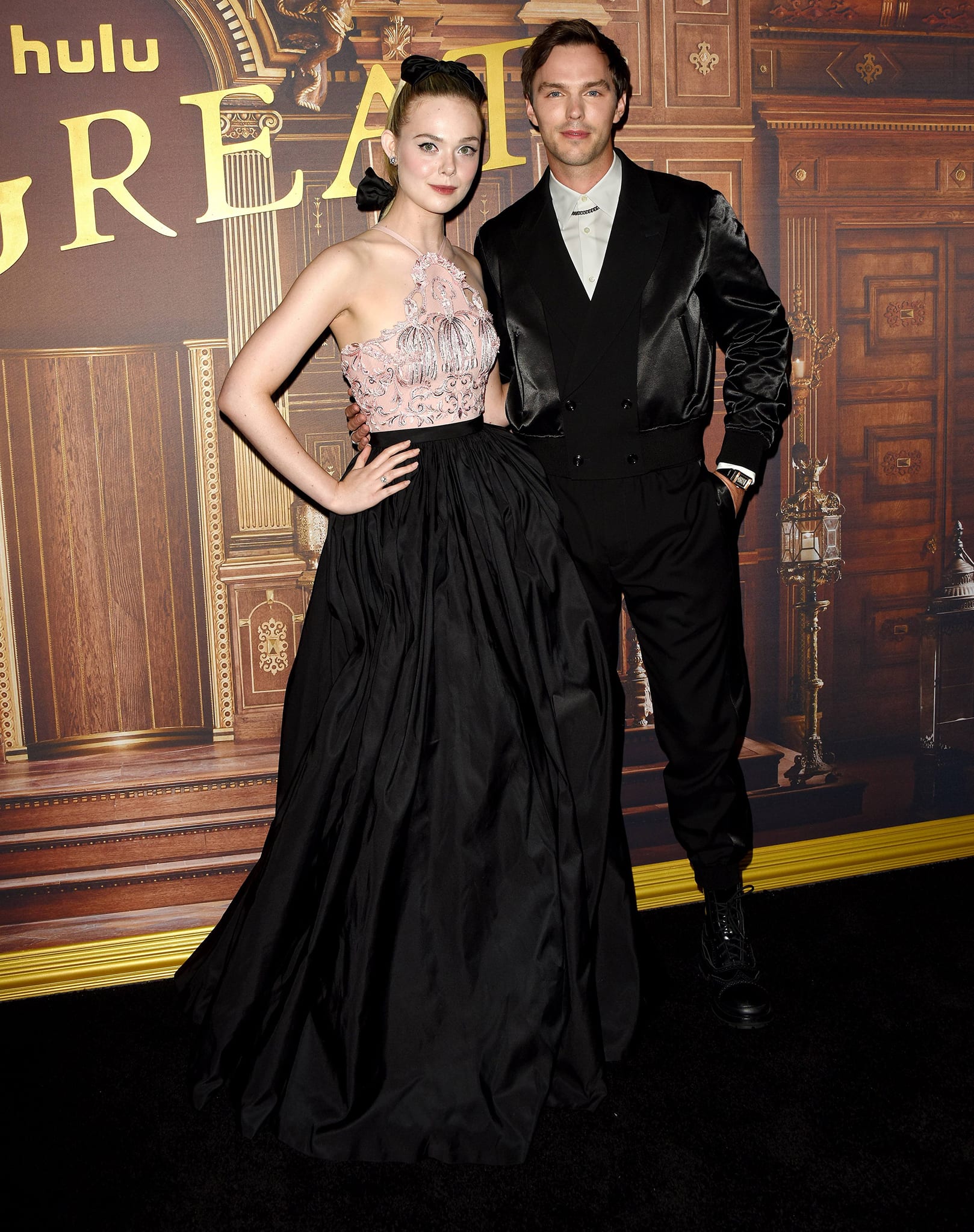 Elle Fanning channels regal modern glamour in a pink, crystal-embroidered halter gown with a flowing black skirt as she joins Nicholas Hoult in a sleek black suit at The Great season two premiere