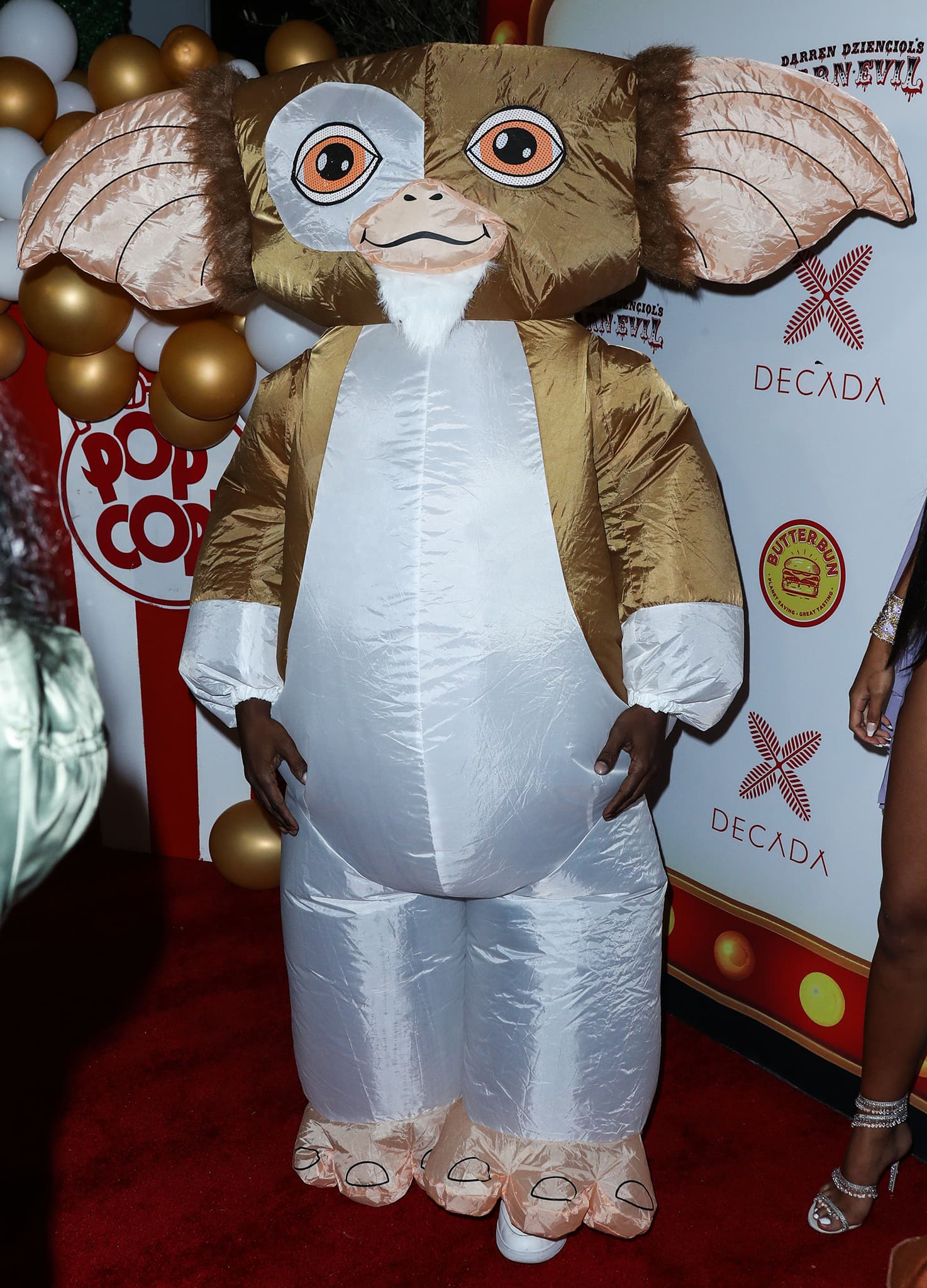 Jamie Foxx keeps it playful in an oversized inflatable Gizmo costume inspired by the beloved Gremlins character, pairing the puffed-up suit with casual white sneakers peeking out underneath for a humorous red-carpet twist