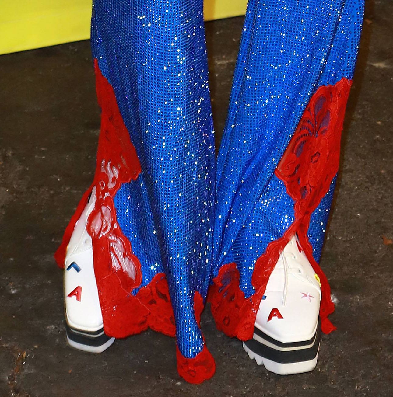 Kate Hudson grounds her crystal-studded Stella McCartney look with the brand’s signature white Elyse platform sneakers, their bold black-striped soles adding modern contrast to the retro sparkle