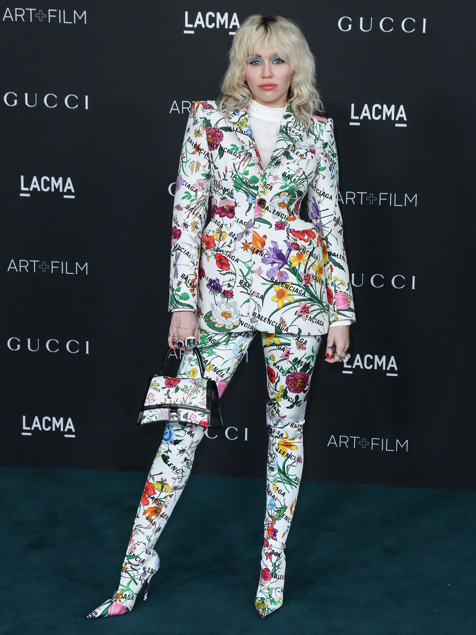 Miley Cyrus attends the 10th Annual LACMA Art + Film Gala in Los Angeles on November 6, 2021, wearing a floral Gucci x Balenciaga Hacker Project suit with matching pointed-toe boots and handbag
