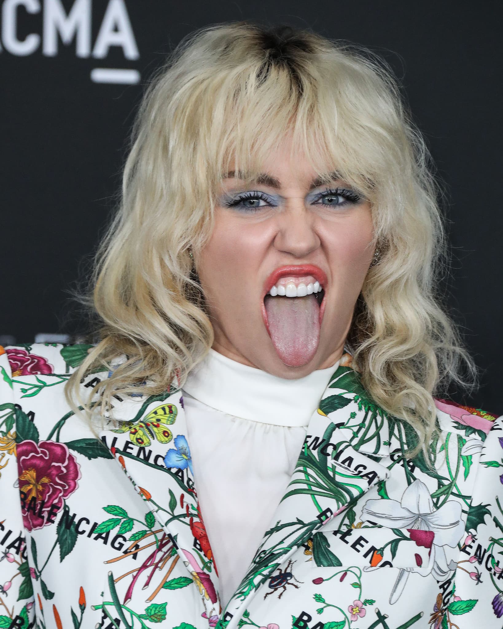 Miley Cyrus highlights her eyes with powder blue eyeshadow and wears her bleached blonde shag in waves