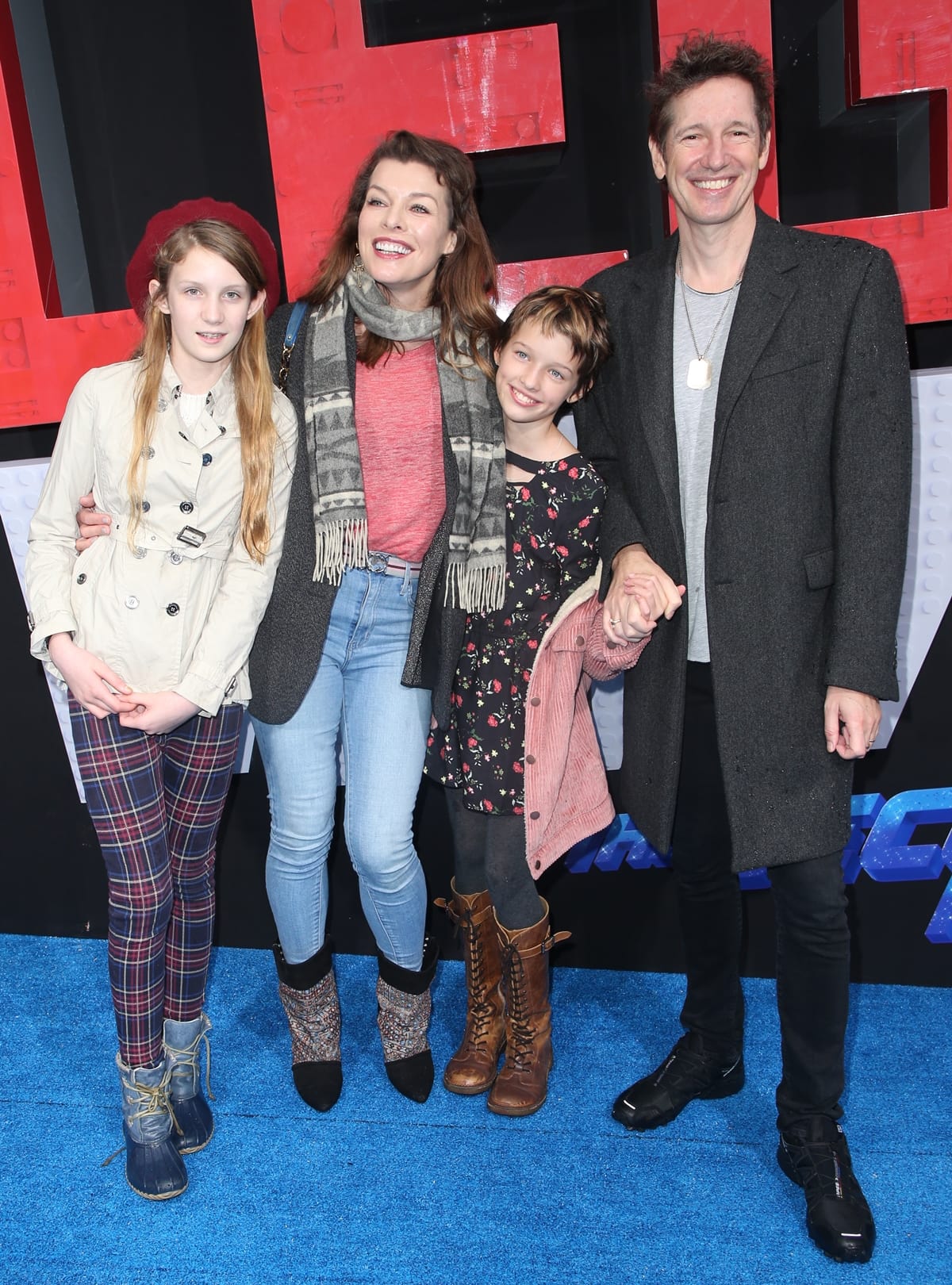 Milla Jovovich, Paul W.S. Anderson, and their daughter Ever Anderson embrace relaxed family style in statement boots and sneakers at the 2019 premiere of The Lego Movie 2: The Second Part in Westwood, California