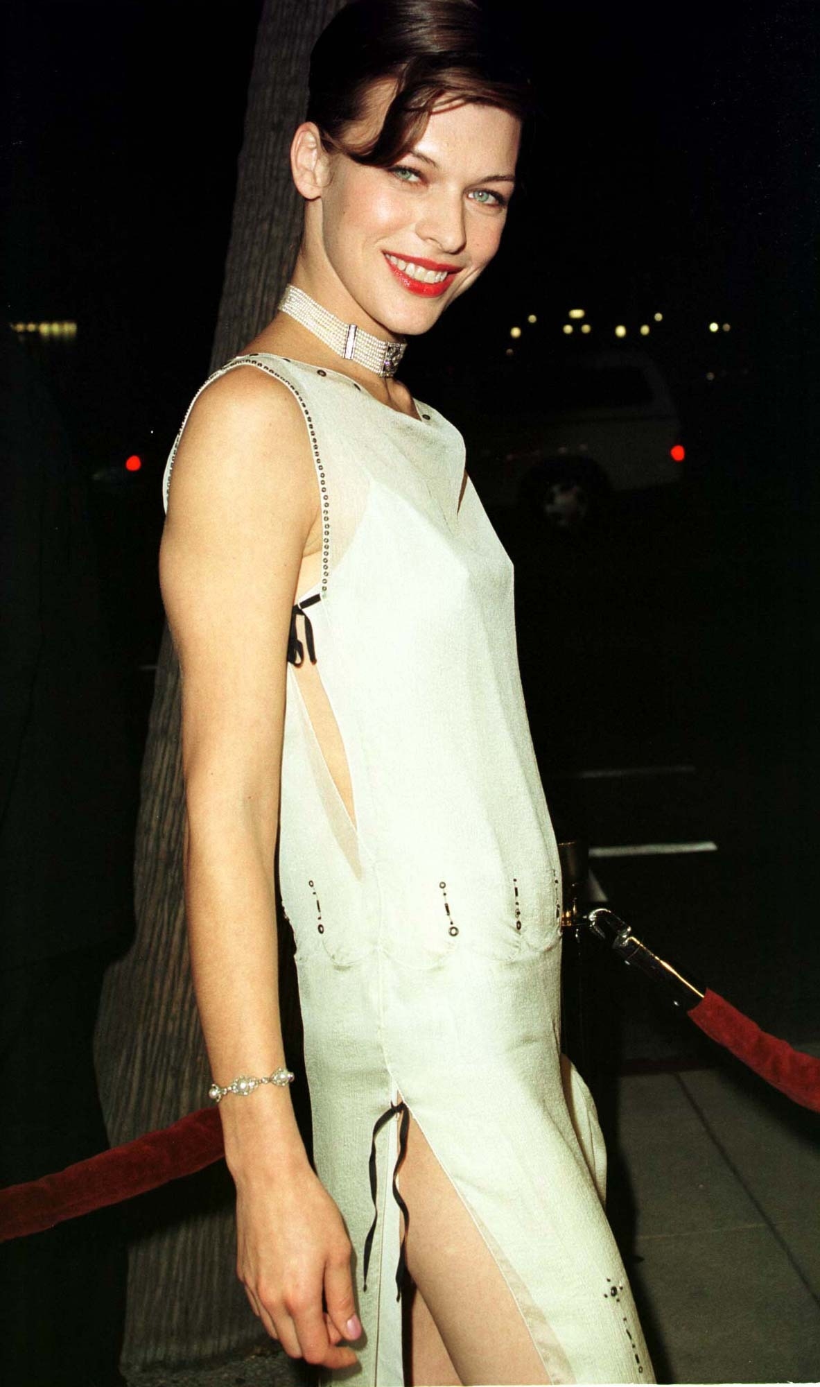 Milla Jovovich glows in a sleek ivory gown with side cutouts and crystal embellishments at the Beverly Hills premiere of The Messenger: The Story of Joan of Arc on October 18, 1999 — a look that reflected both her daring spirit and early red-carpet confidence