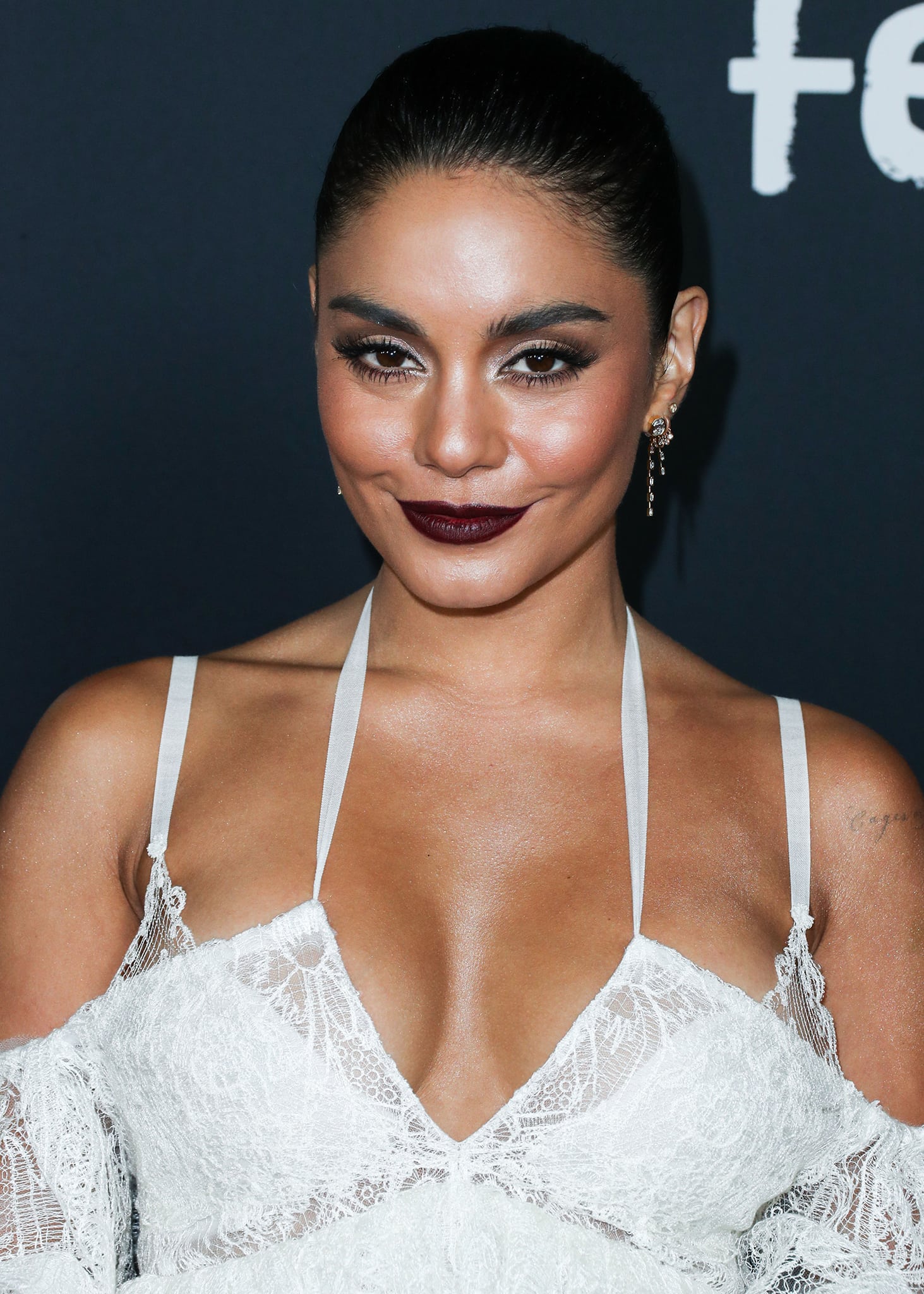 Vanessa Hudgens glams up with smoky eyeshadow, plum lip color, and braided ponytail