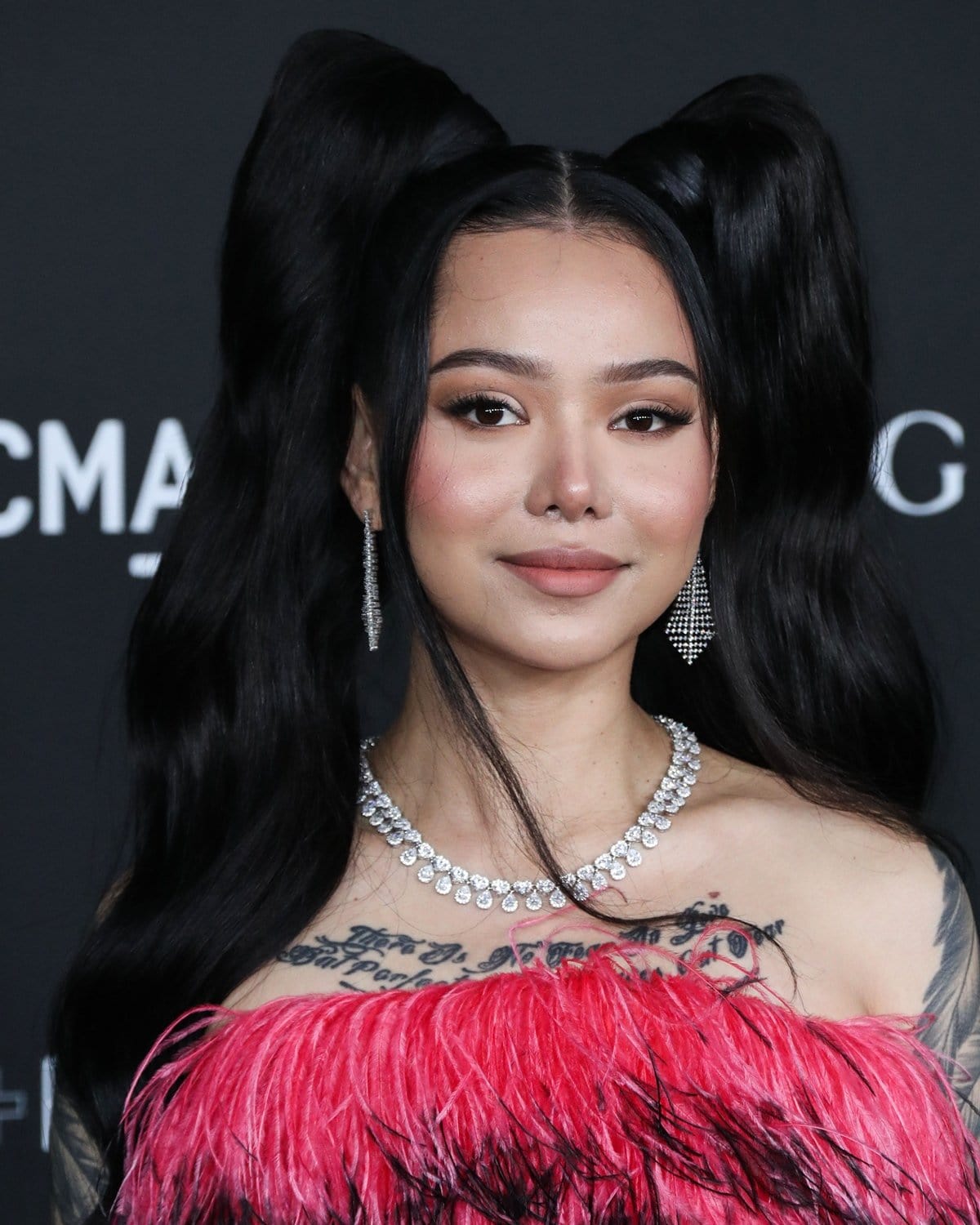Bella Poarch stuns in a pink feathered Marcell Von Berlin dress, complemented by sparkling diamond accessories, at the LACMA Art+Film Gala