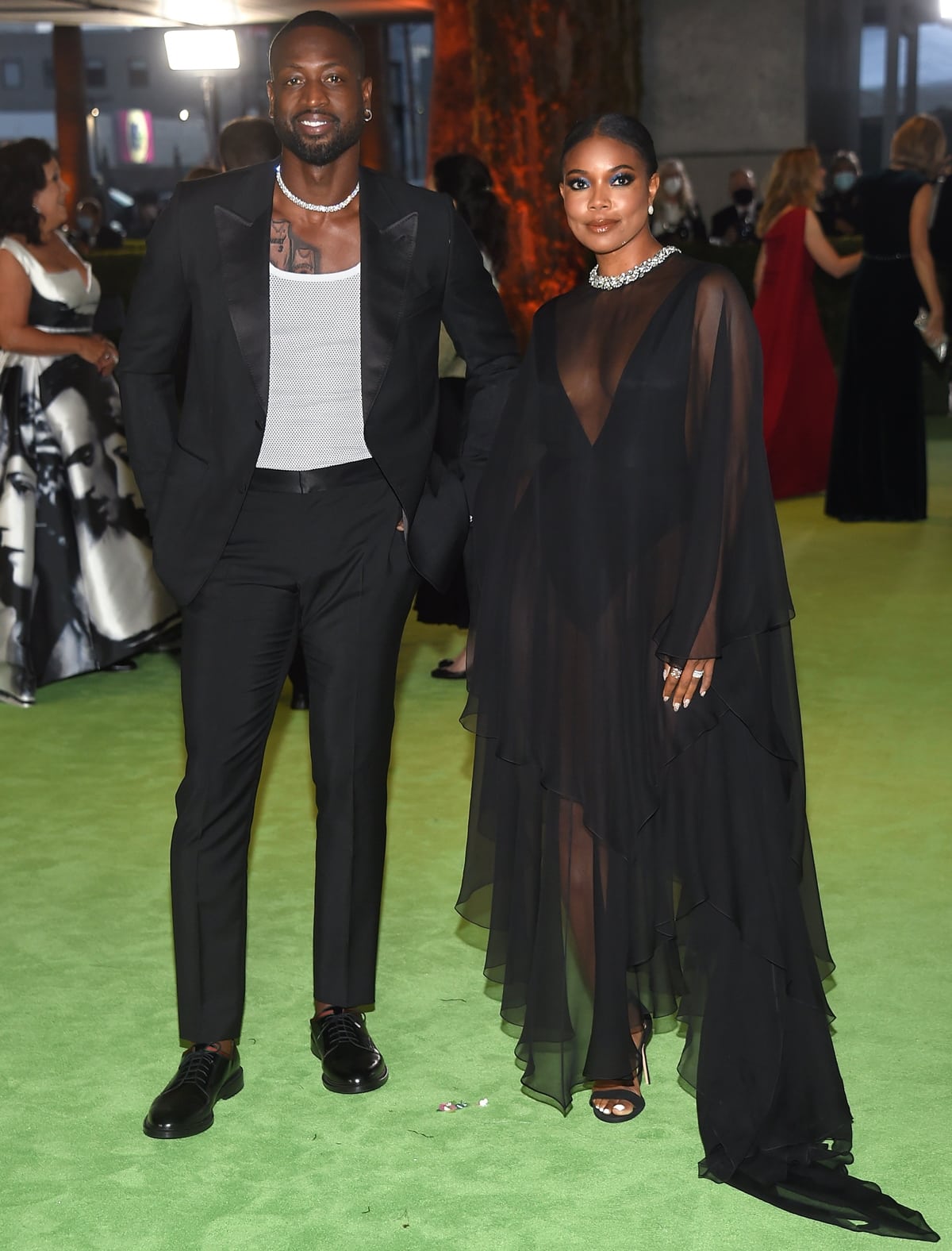 Gabrielle Union and Dwyane Wade stepped out in coordinated black evening looks, with Union floating in a sheer, layered gown paired with minimalist open-toe heels while Wade kept it sharp in a tailored suit and polished leather shoes, the couple delivering a sleek, modern take on red-carpet elegance