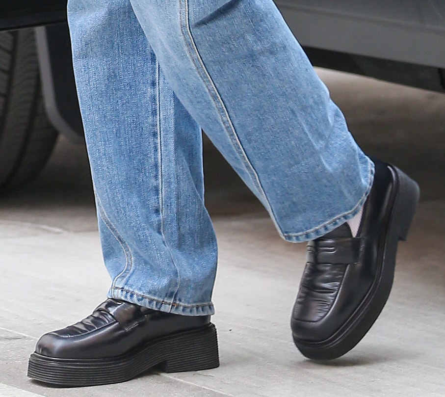 Hailey Bieber grounds her relaxed denim with chunky black leather penny loafers, their square toes and platform soles adding a polished, fashion-forward edge to her off-duty Beverly Hills look