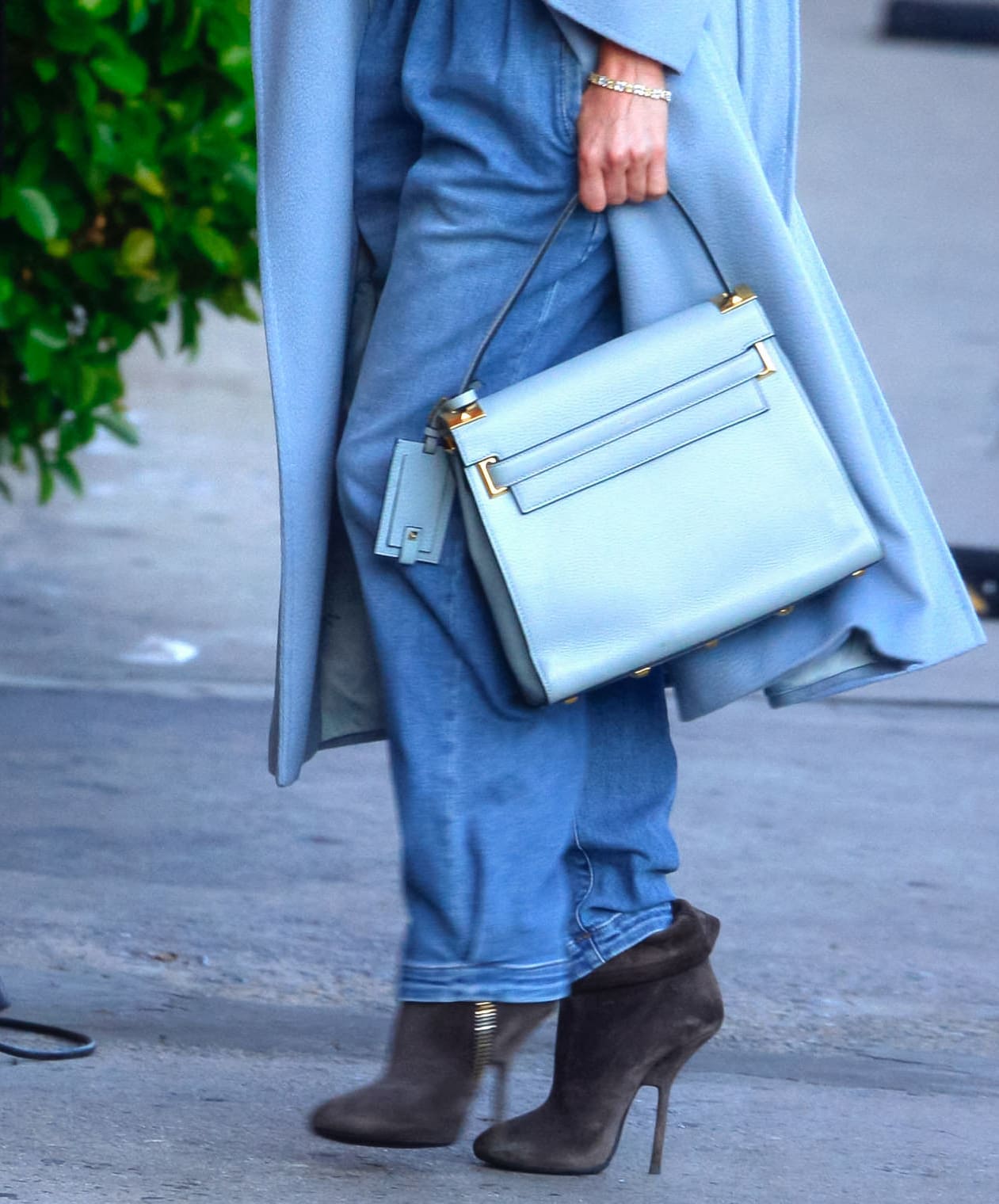 Jennifer Lopez coordinated icy-blue tones with a structured Valentino top-handle bag and gray suede Giuseppe Zanotti “Vera” ankle boots, adding soft texture and sharp stiletto lines to her winter-ready street style