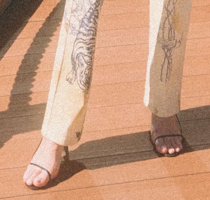 Kendall Jenner slipped into minimalist black sandals with barely-there straps, subtly elongating her legs beneath printed Roberto Cavalli jeans
