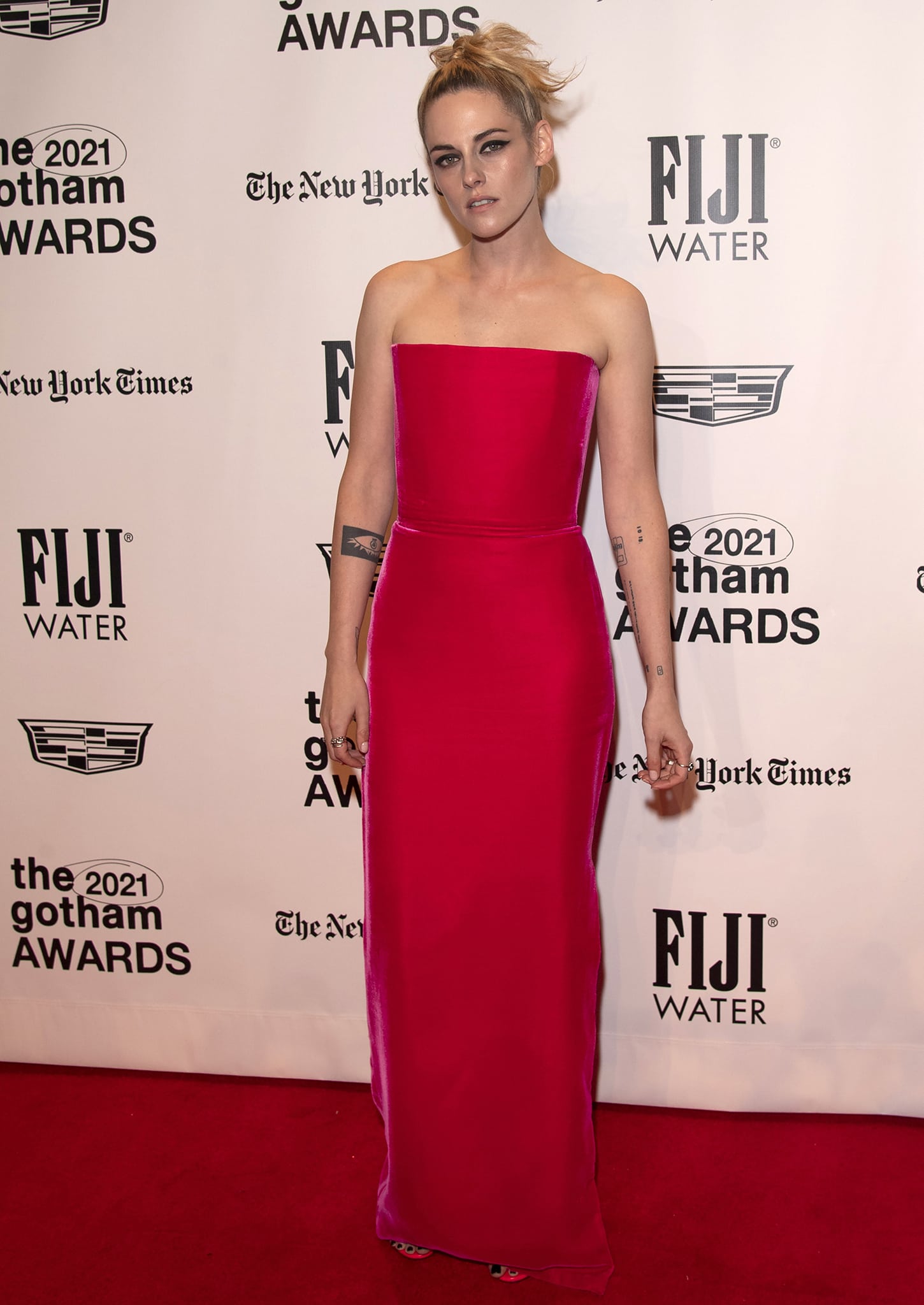 Kristen Stewart accepts the Performer Tribute honor in a sculpted strapless hot pink August Getty Atelier column gown, styled with matching Tamara Mellon “Frontline” PVC-paneled sandals that subtly elongate the silhouette at the 31st Annual Gotham Awards at Cipriani Wall Street on November 29, 2021