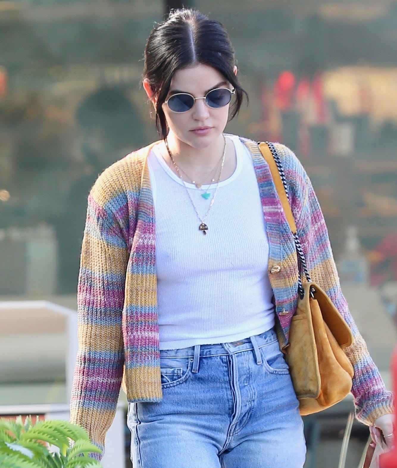 Lucy Hale accessorizes her casual outfit with a mustard-yellow suede Saint Laurent "Niki" shoulder bag, layered gold necklaces, and round sunglasses while wearing a colorful Line Dot cardigan over a fitted white ribbed tank