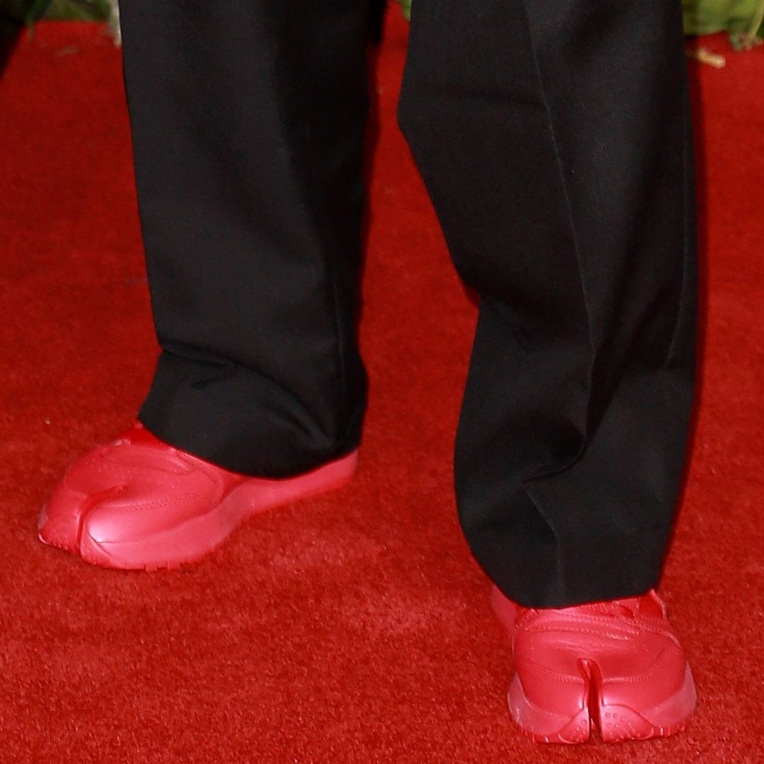Nick Jonas added an unexpected pop of color with bright red Maison Margiela x Reebok Tabi sneakers, pairing the signature split-toe design with an oversized black tuxedo for one of the evening's most unconventional menswear looks