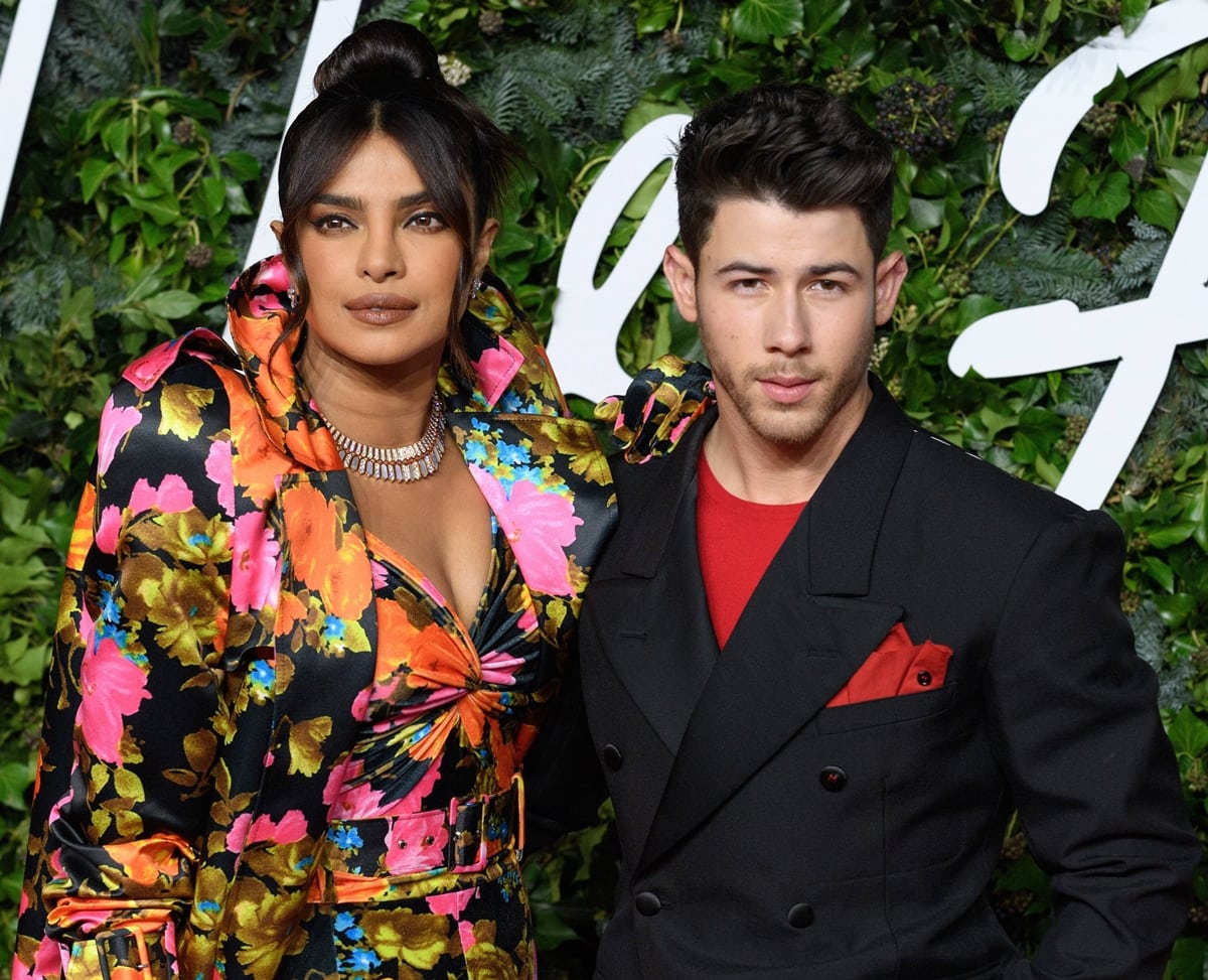 Priyanka Chopra finished her dramatic Richard Quinn look with Bulgari diamonds and a sculptural topknot as Nick Jonas coordinated in a black double-breasted Maison Margiela ensemble with bold red accents