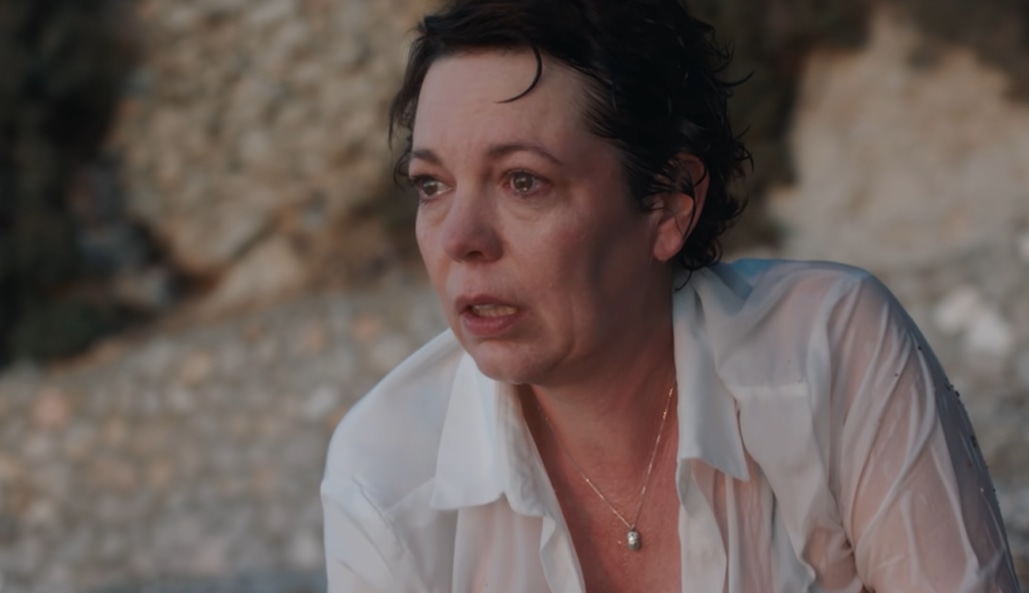Olivia Colman portrays Leda Caruso in The Lost Daughter, capturing one of the film’s most emotionally raw and sun-drenched moments on the Greek coast