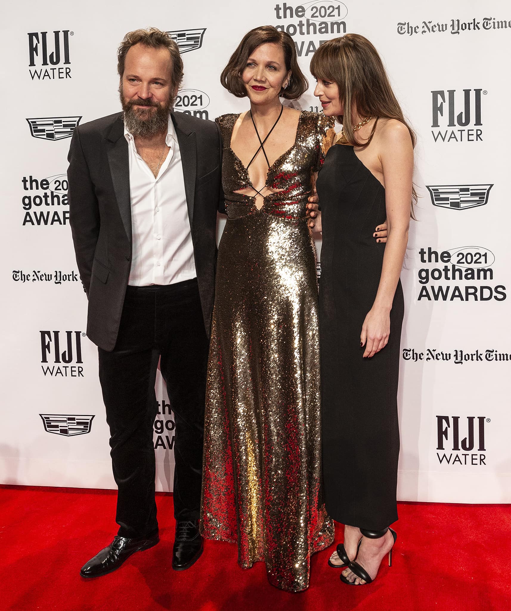 Peter Sarsgaard, Maggie Gyllenhaal, and Dakota Johnson pose together at the 31st Annual Gotham Awards, with Dakota adding a sleek touch in minimalist black ankle-strap sandals