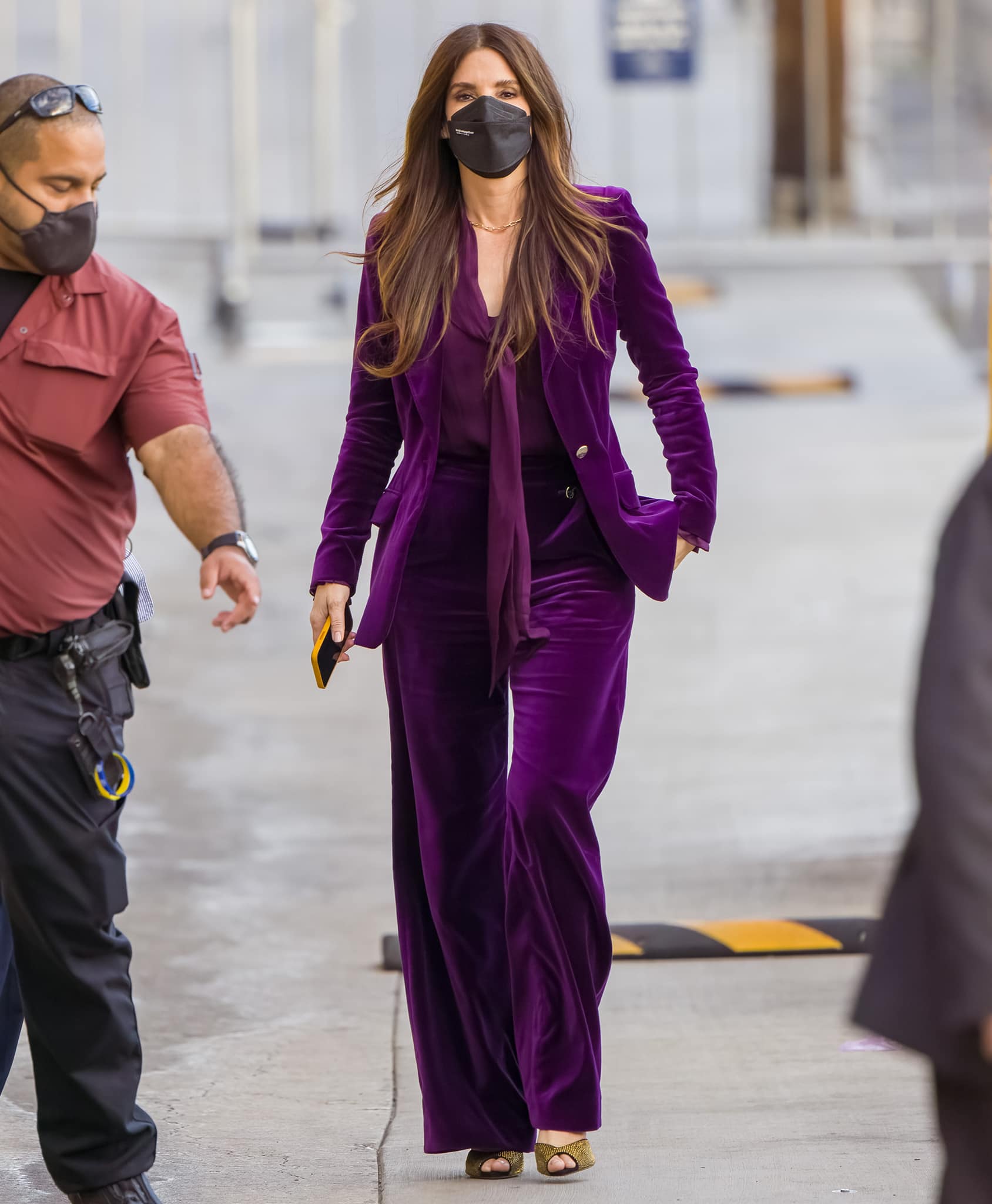 The wide-leg proportions of Bullock’s Temperley London tailoring nearly conceal her statement heels, leaving flashes of Alexandre Birman’s crystal-studded suede visible beneath the hems