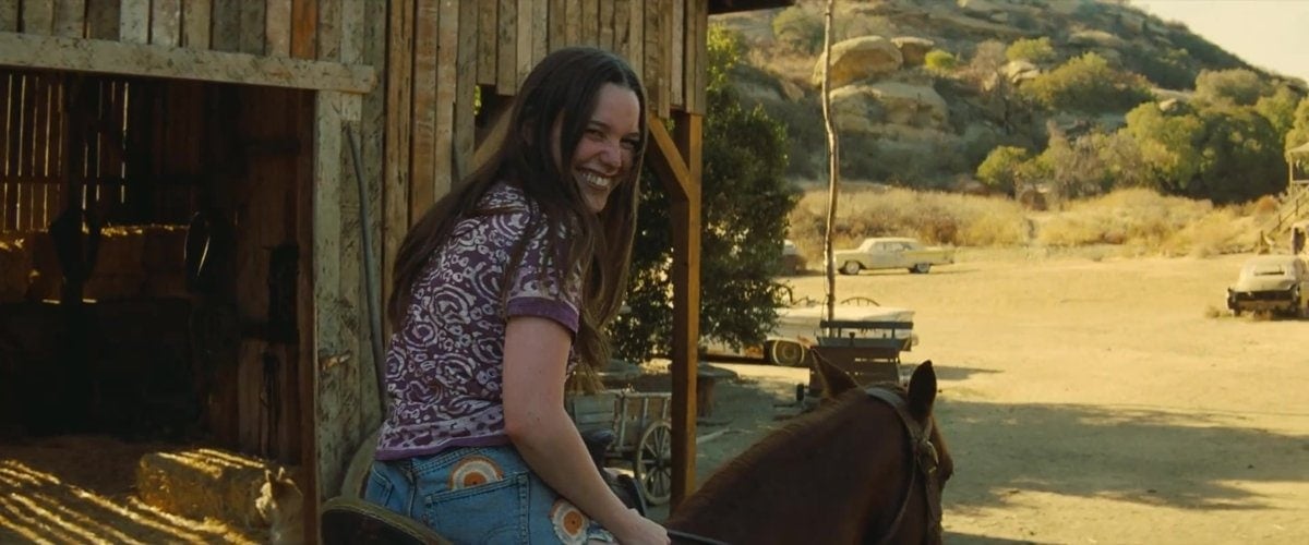 Victoria Pedretti as Leslie "Lulu" Van Houten, smiling during a scene from Once Upon a Time in Hollywood, capturing her carefree portrayal of the Manson family member