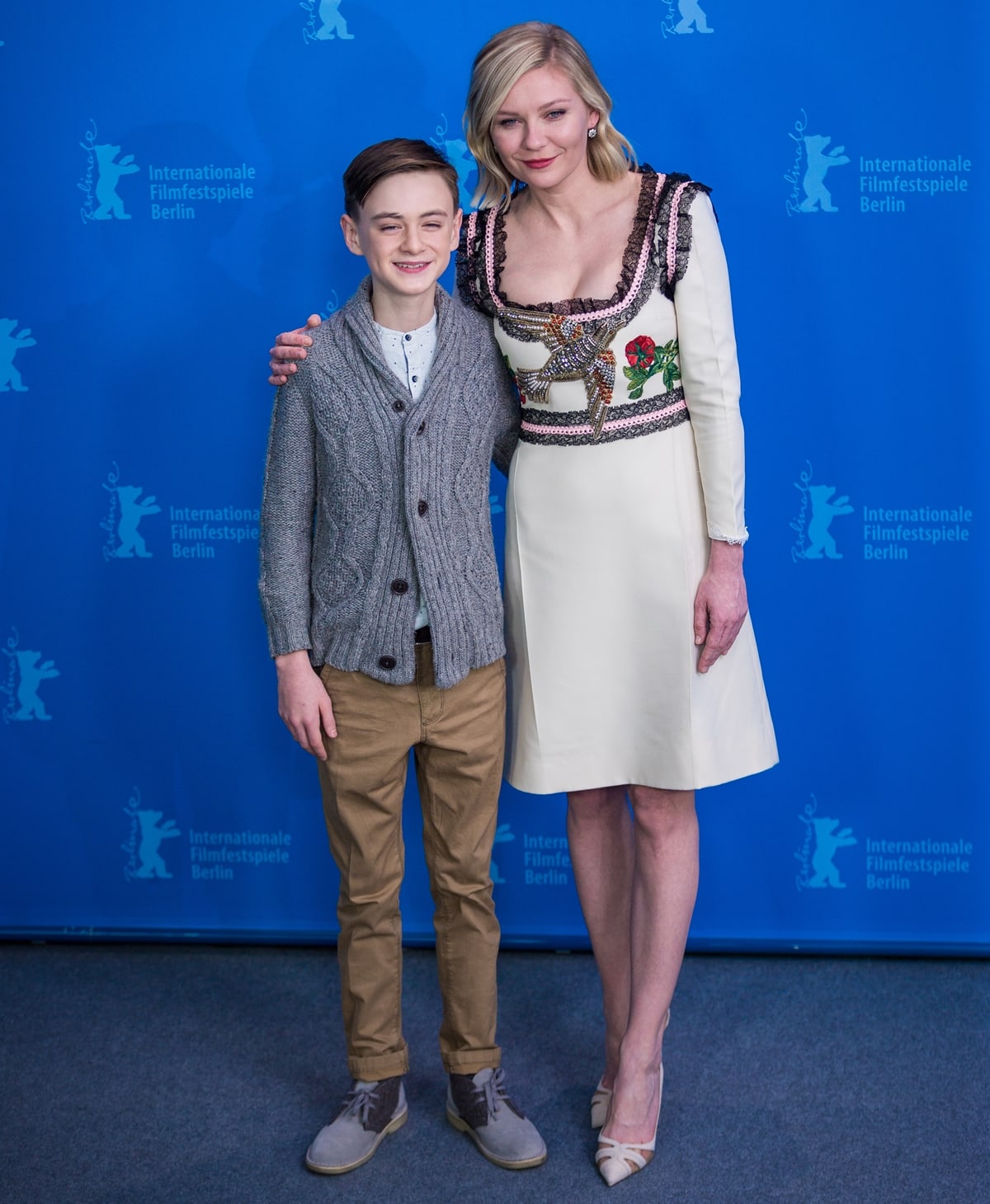 Jaeden Lieberher and Kirsten Dunst attend the Midnight Special photocall at the 66th Berlinale International Film Festival in Berlin on February 12, 2016, with Dunst completing her embroidered cream dress in pointed-toe Salvatore Ferragamo heels featuring sleek cutout detailing and a low, leg-lengthening stiletto