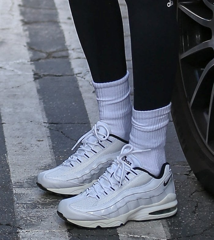 Bella Hadid adds a sporty edge to her Pilates look with crisp white crew socks and classic Nike Air Max 95 sneakers, blending retro streetwear vibes with sleek modern comfort
