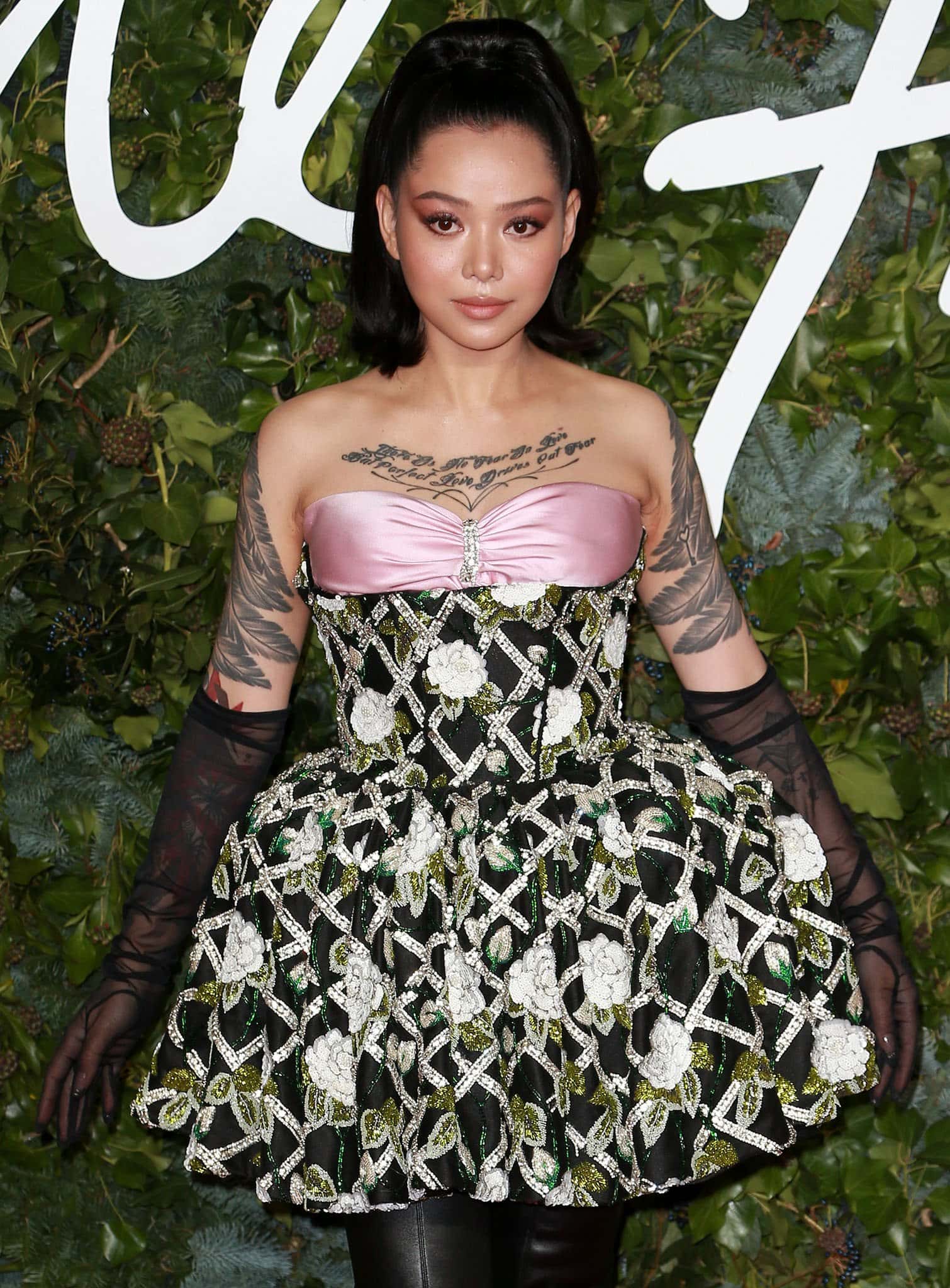 Bella Poarch makes a bold statement in a structured floral mini dress with a satin pink bustier and sheer gloves, showing how to turn heads with high-impact fashion on a very petite frame