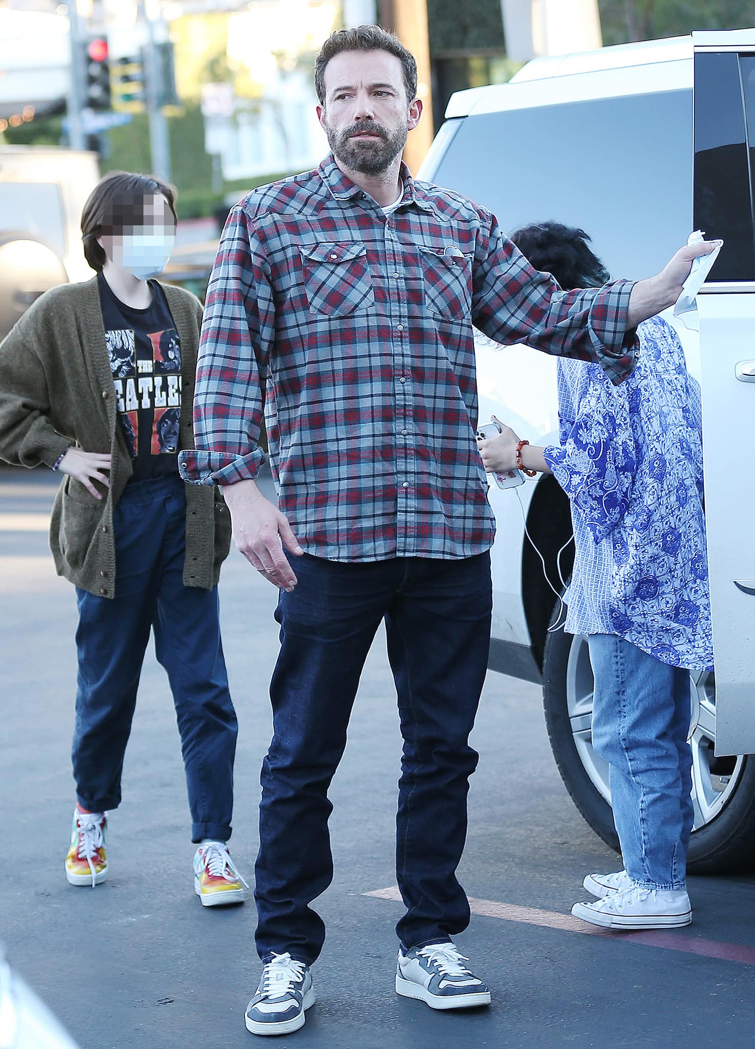 Ben Affleck keeps it low-key in a plaid flannel shirt, dark blue jeans, and classic casual sneakers while out with family