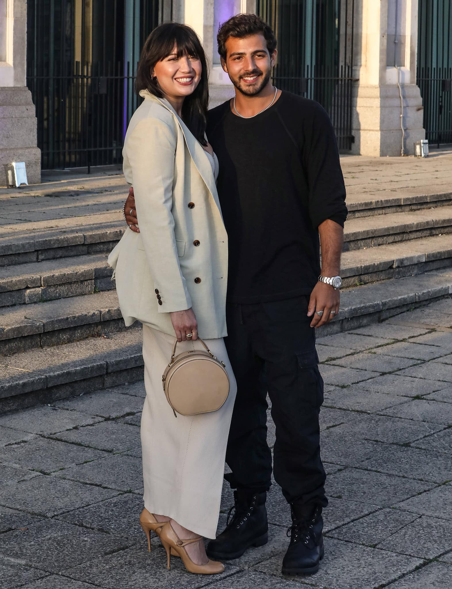 Daisy Lowe steps out in a softly tailored neutral suit paired with classic beige pointed-toe pumps, posing alongside boyfriend Jordan Saul—whom she met in 2020 while walking their dogs