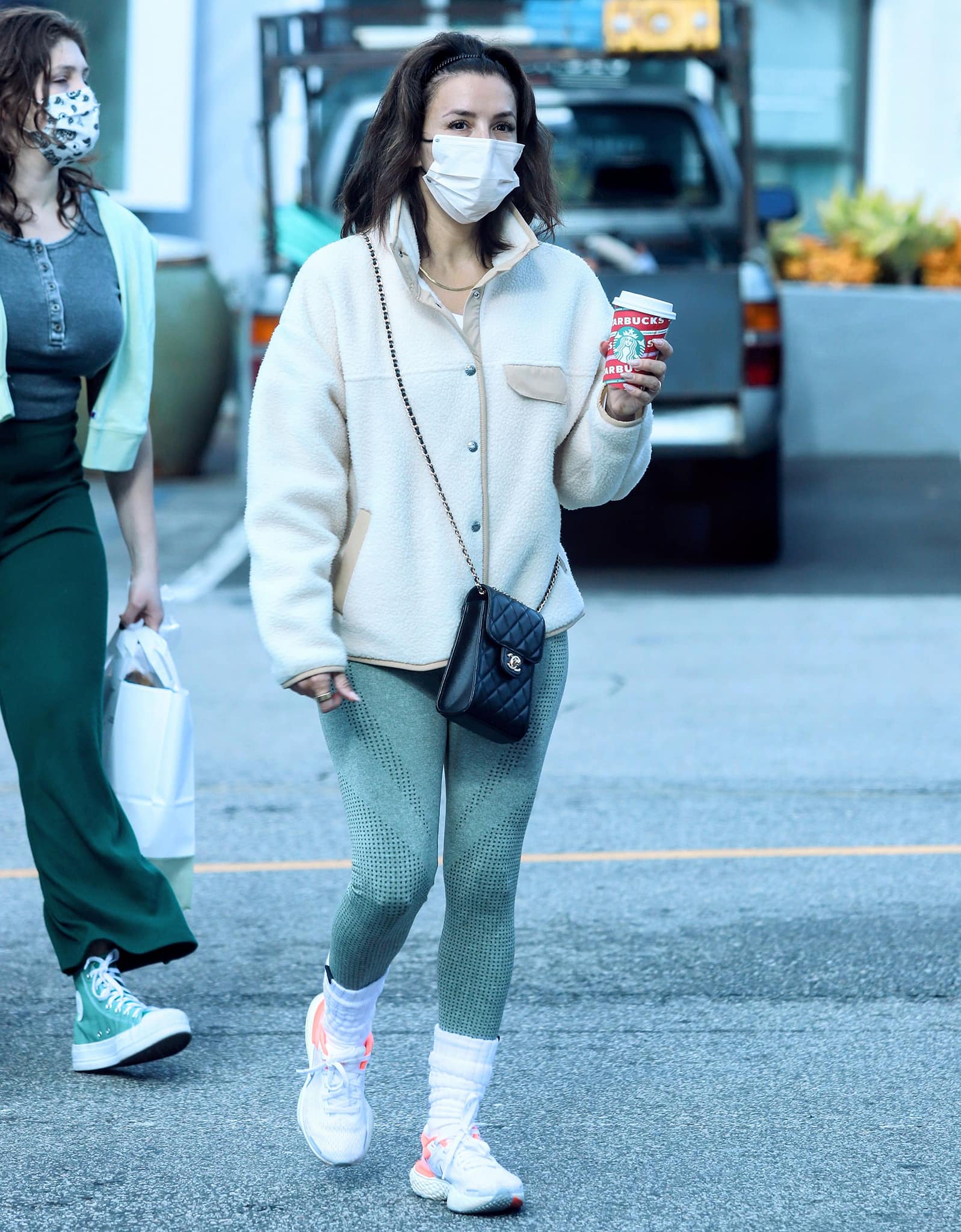 Eva Longoria paired her casual North Face fleece with a black quilted Chanel phone bag and a delicate gold chain necklace, balancing luxury and utility