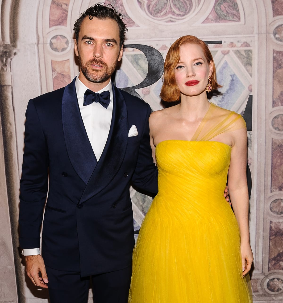 Jessica Chastain stunned in a strapless yellow tulle gown while posing with her husband Gian Luca Passi de Preposulo, who looked sharp in a navy tuxedo with a satin lapel and bow tie