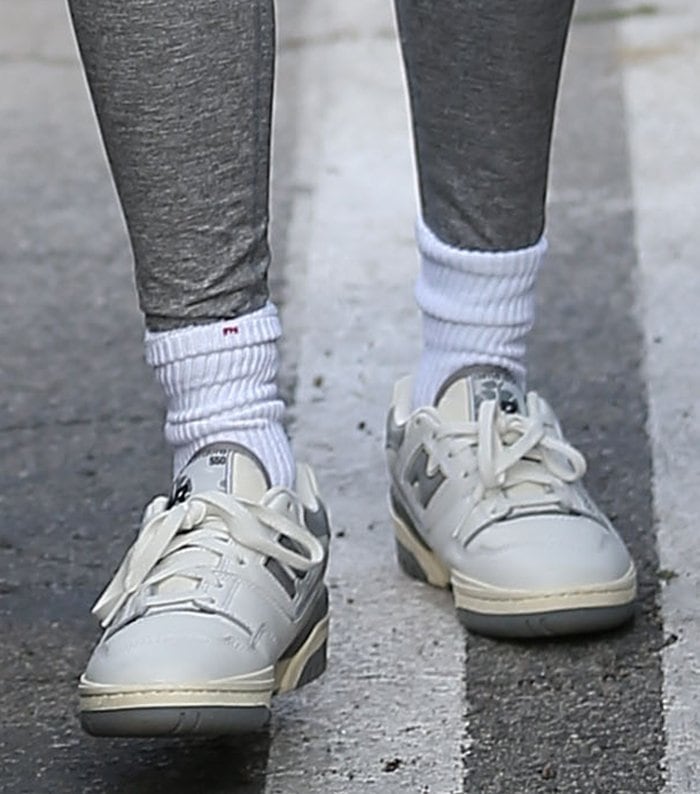 Hailey Bieber finishes her monochrome Pilates look with crisp white tube socks and the coveted Aimé Leon Dore × New Balance P550 sneakers in white and gray—a perfect fusion of New York streetwear nostalgia and refined craftsmanship