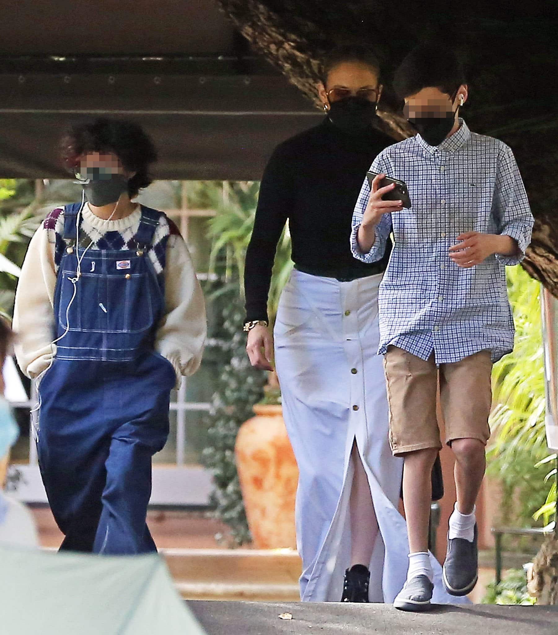 Jennifer Lopez steps out for lunch at Hotel Bel-Air with twins Emme and Max, pairing a fitted black turtleneck bodysuit with a flowing white button-front maxi skirt and towering black platform boots
