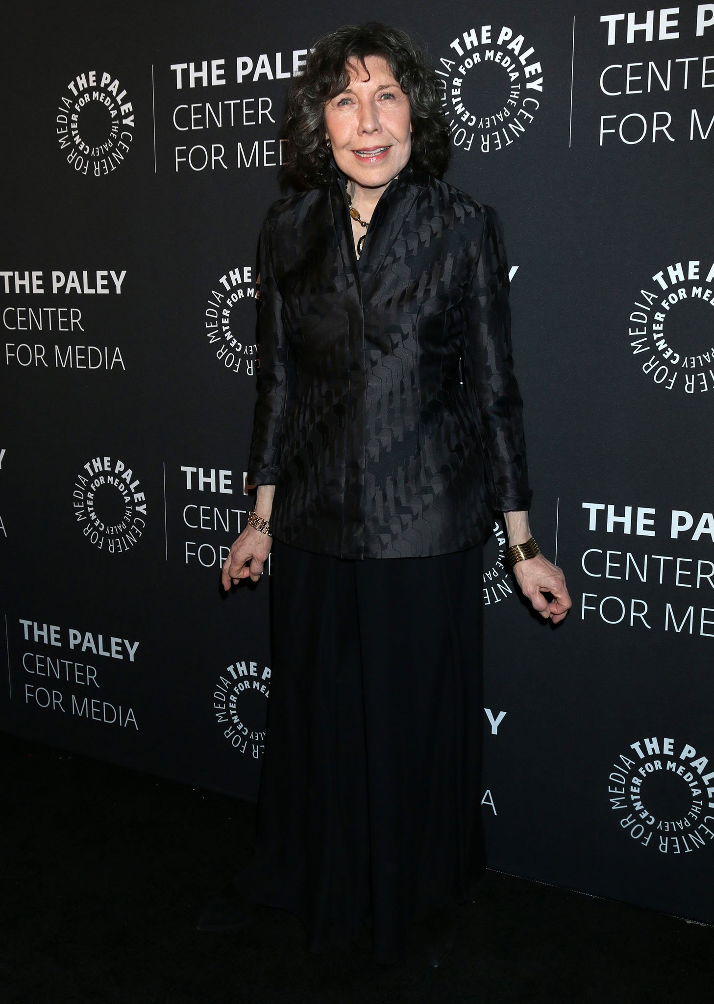 Lily Tomlin keeps it classic in an all-black ensemble featuring a subtly patterned blazer and flowing trousers, pairing timeless elegance with understated sophistication for her appearance at The Paley Center for Media