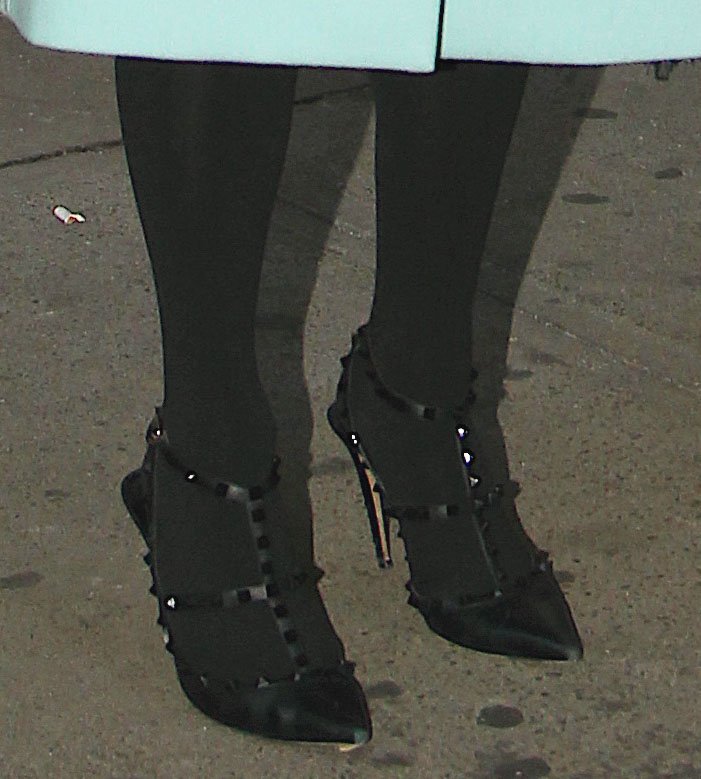 Close-up of Paris Hilton's black Valentino Rockstud pointed-toe pumps worn over black tights