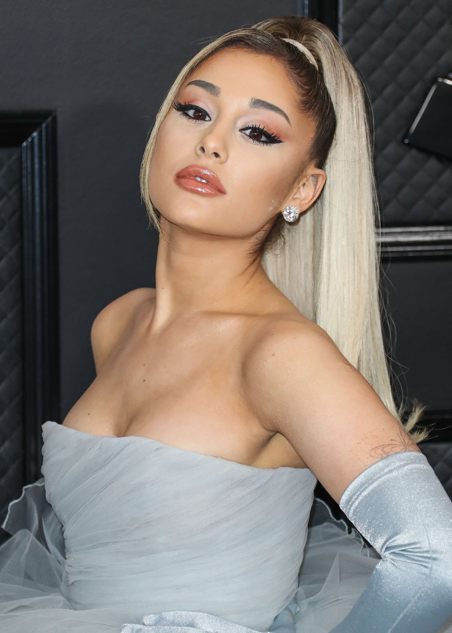 Ariana Grande shows off her signature high ponytail while posing in a strapless gown and opera gloves