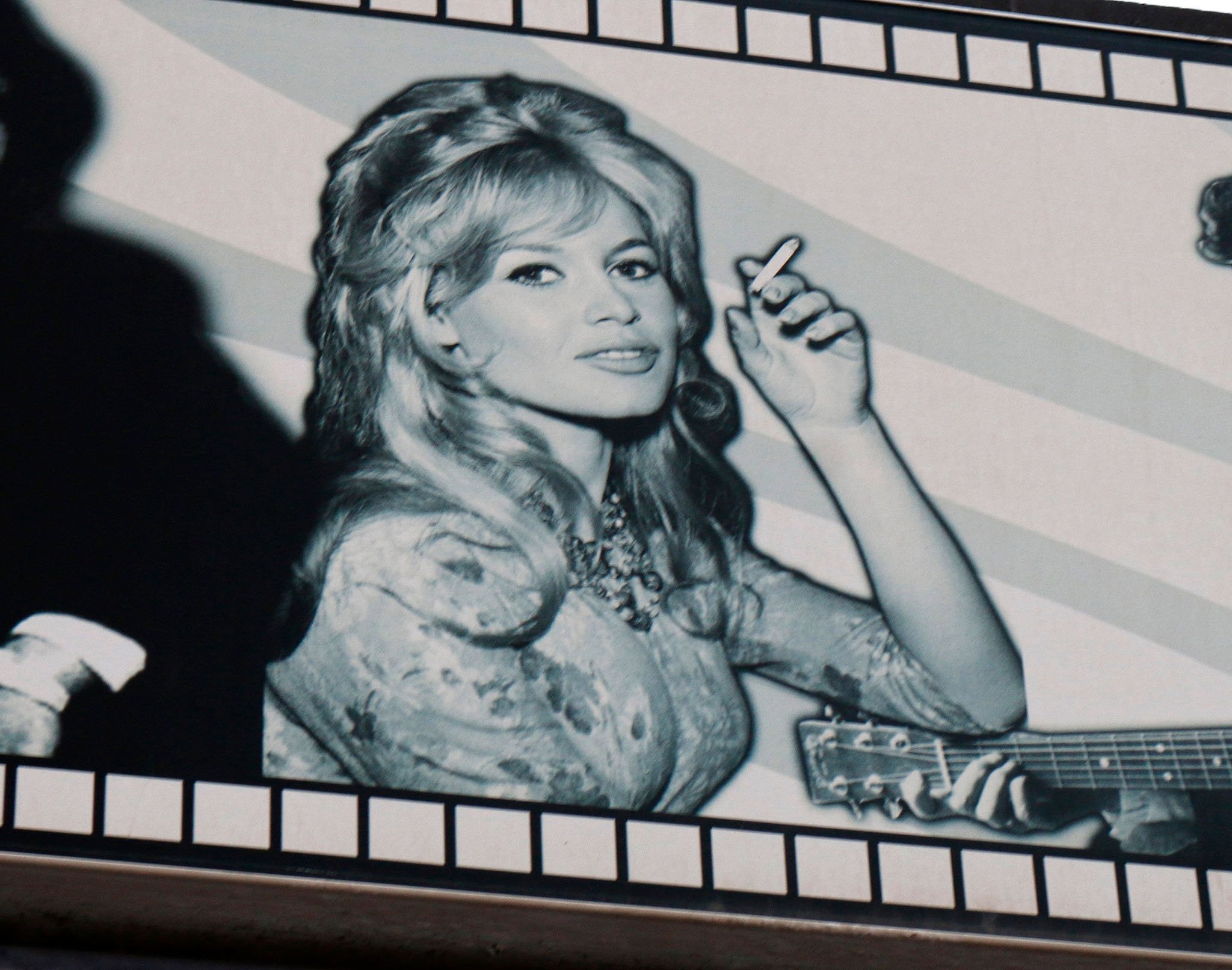 Brigitte Bardot, standing at 5 feet 5 ½ inches (166.4 cm), epitomized French glamour with her voluminous hair, hourglass silhouette, and signature sultry gaze in this iconic retro portrait