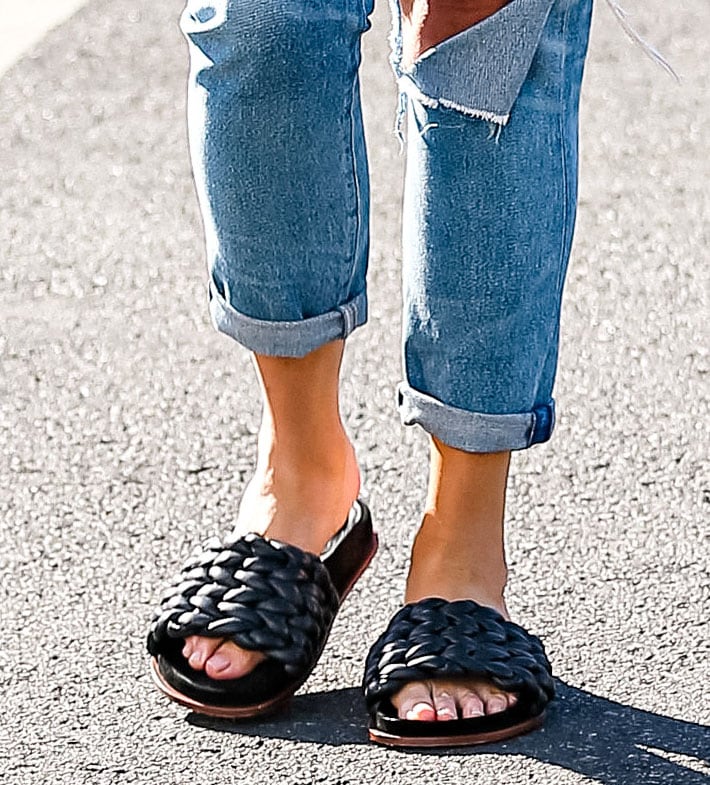 Chloé Kacey slide sandals, woven from panels of supple black leather, ground Chrissy Teigen’s off-duty look as she pairs them with cuffed distressed jeans in West Hollywood