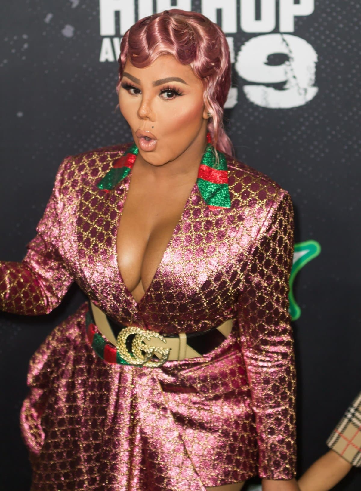 Lil’ Kim turned heads at the 2019 BET Hip Hop Awards in a sparkling pink and gold Gucci ensemble, cinched at the waist with a crystal-embellished Gucci logo belt and styled with vintage-inspired finger waves and bold glam