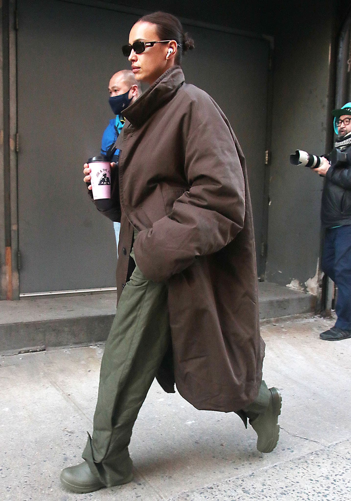 Irina Shayk wears an oversized brown coat with olive wide-leg pants and UGG Tasman X clogs in New York City