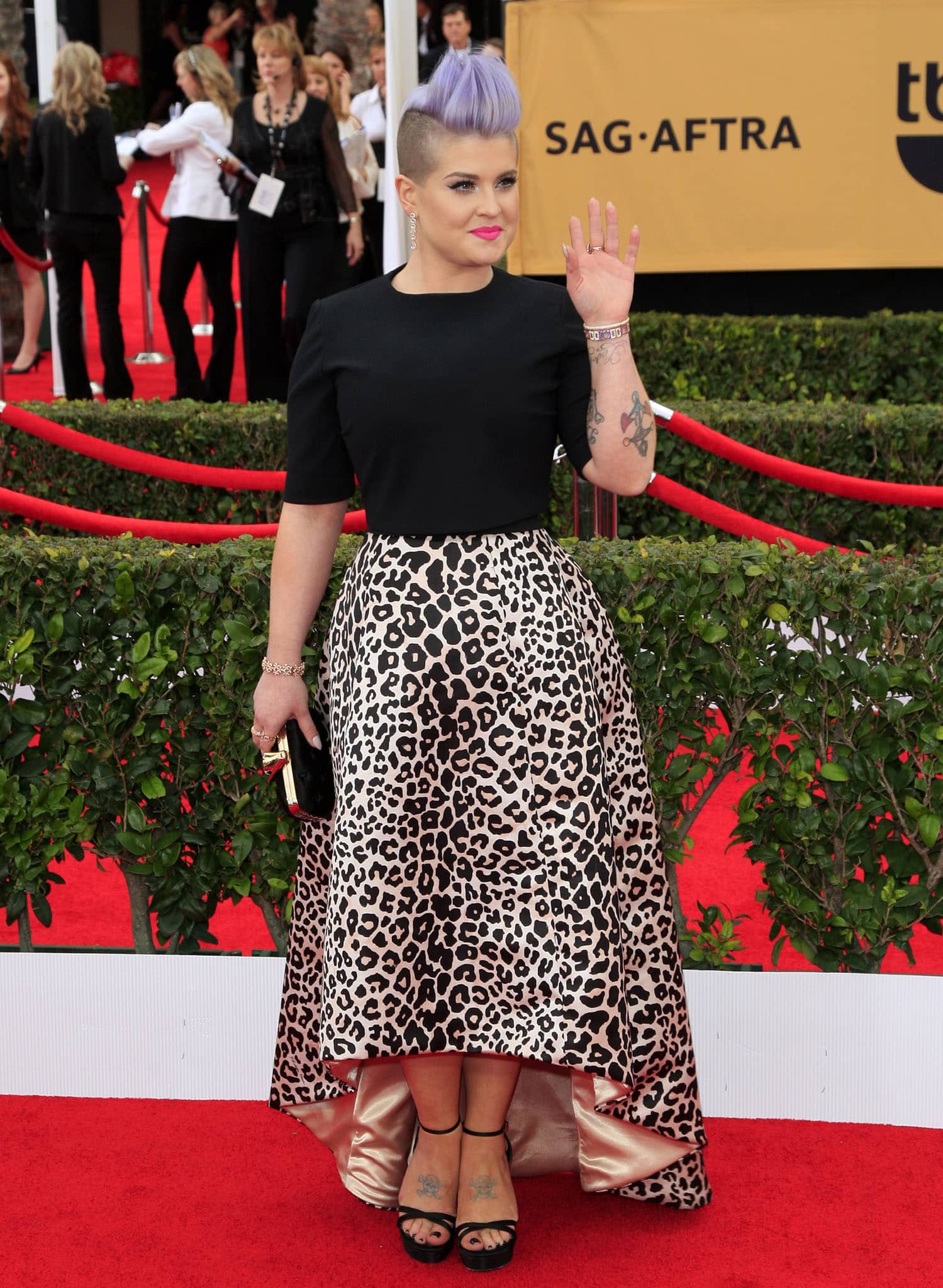 Kelly Osbourne paired a black short-sleeve top and leopard-print high-low skirt with black ankle-strap platform sandals at the SAG Awards