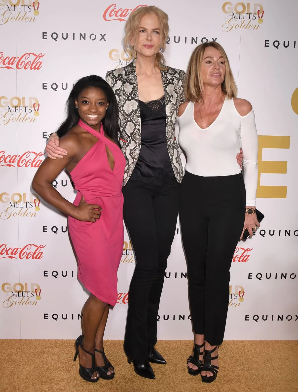Olympic legend Simone Biles stuns in a hot pink halter dress and black platform heels alongside Nicole Kidman, towering in pointed-toe stilettos and sleek black pants, and Nadia Comaneci in a chic white cutout top and strappy sandals at the Gold Meets Golden event on January 7, 2017, in Los Angeles