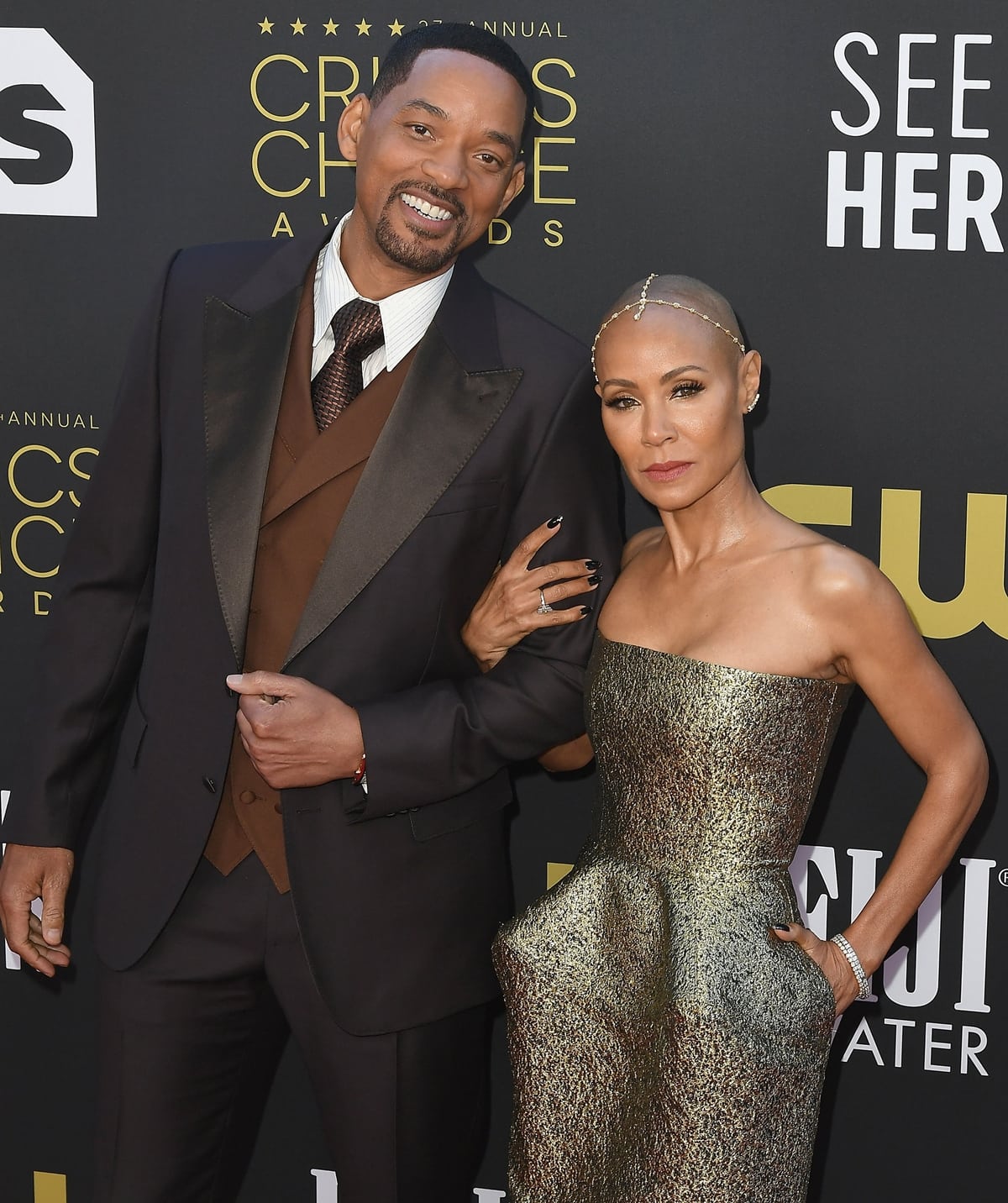 Will Smith, standing tall at 6'1½", towers over Jada Pinkett Smith, who stuns in a shimmering strapless gown, highlighting their height difference and elegant style at the Critics Choice Awards