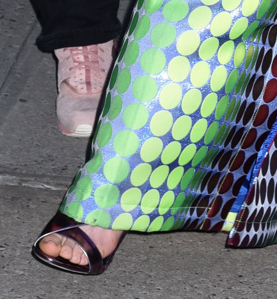 Anne Hathaway completes her colorful look by showing off her feet in Giuseppe Zanotti Lilas sandals in reflective purple leather