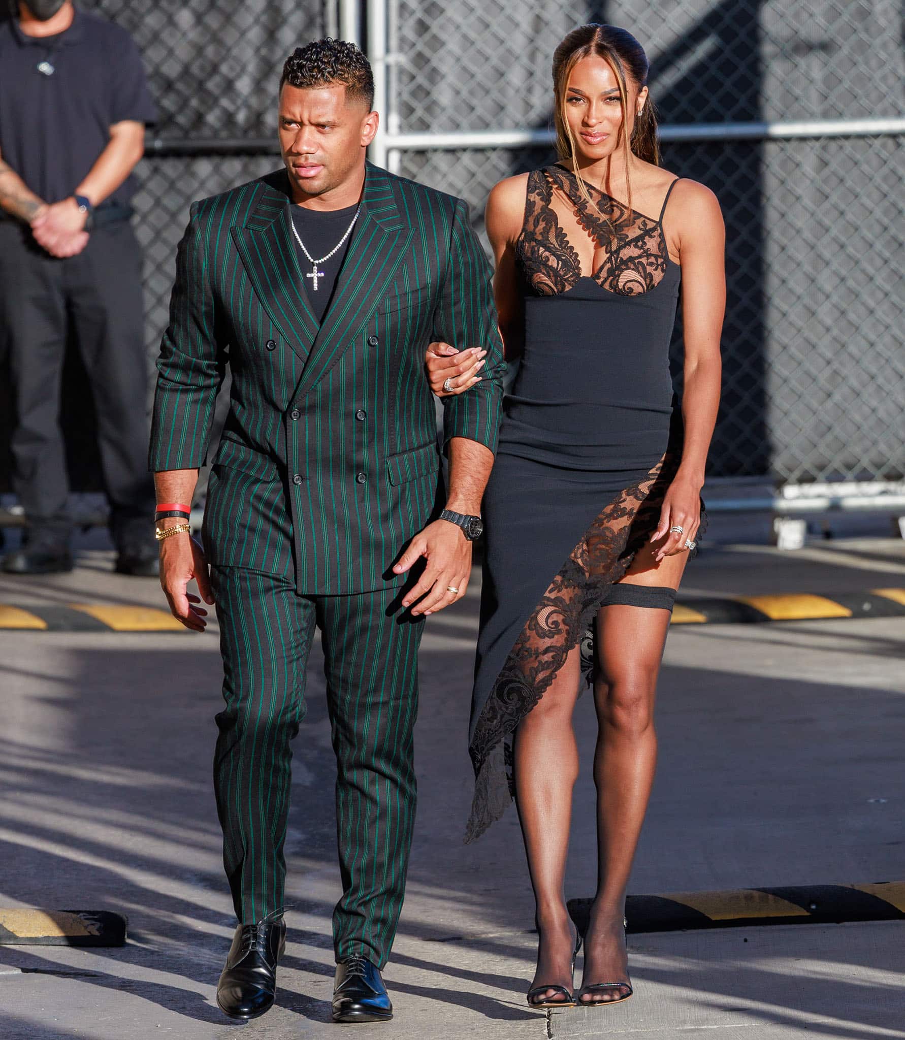 Ciara stuns in a sultry David Koma Resort 2022 black lace dress, featuring an asymmetric neckline, sheer lace panels, and a daring thigh-high slit that showcases her toned legs and impeccable style
