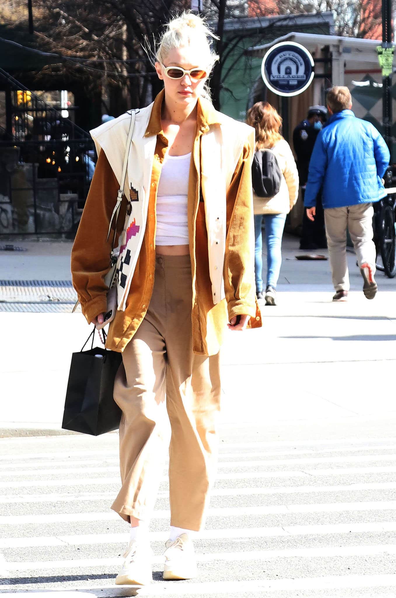 Gigi Hadid debuts bleached brows and platinum blonde hair while stepping out in Soho on March 22, 2022, grounding her earth-toned layers with low-profile Reebok x Victoria Beckham sneakers that keep the look effortlessly understated