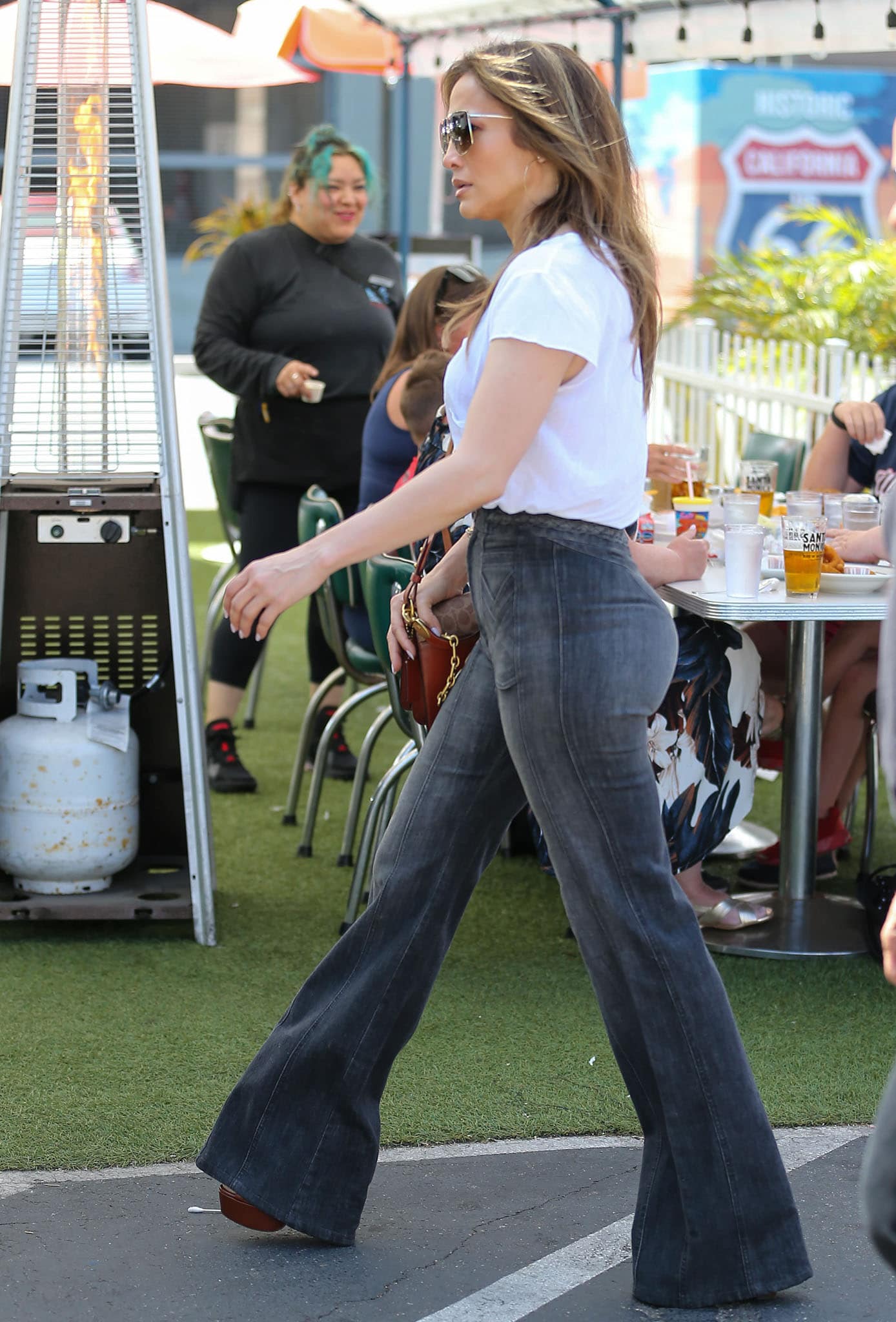 Jennifer Lopez channels effortless weekend glamour in Grey Ant’s braided flared denim pants and Aquazzura “Issa” suede-and-leather platform sandals while brunching in Los Angeles