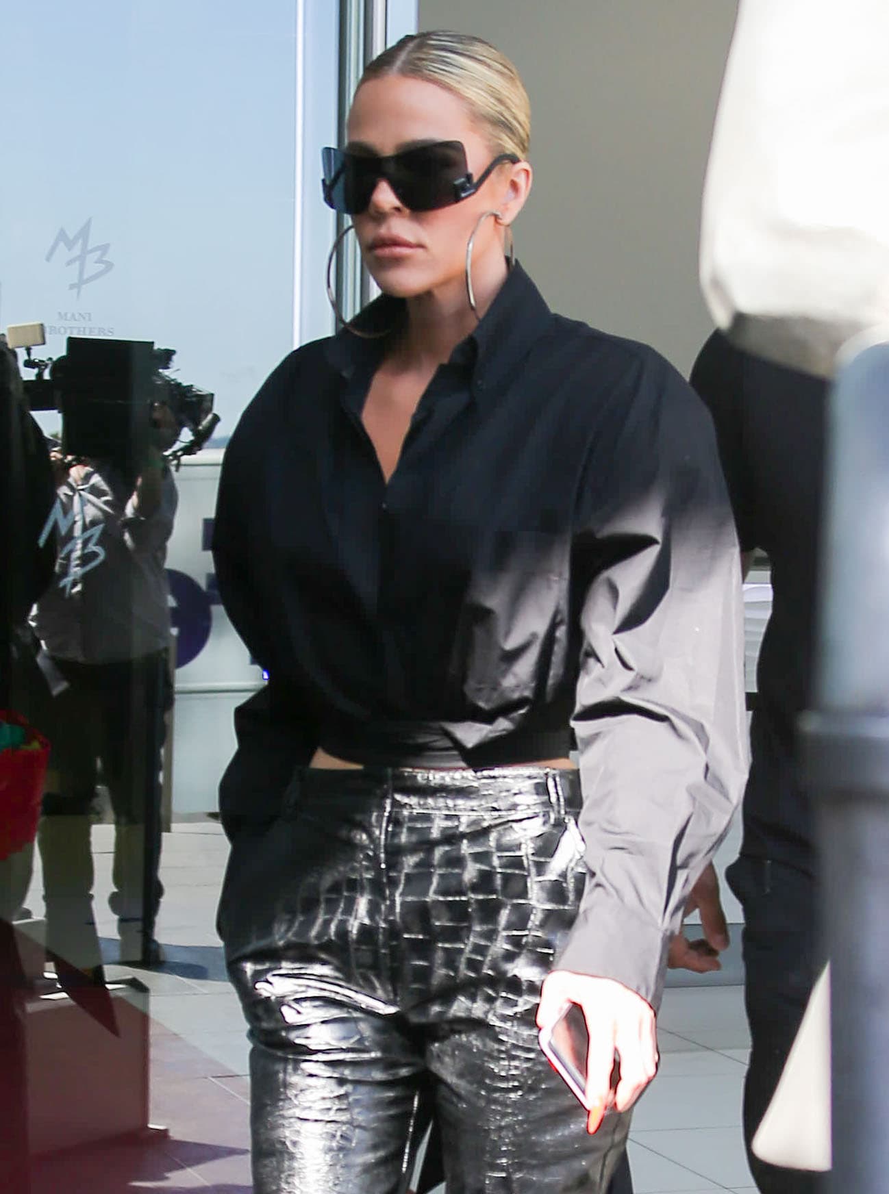 Khloé Kardashian styles her monochromatic black outfit with futuristic Versace sunglasses