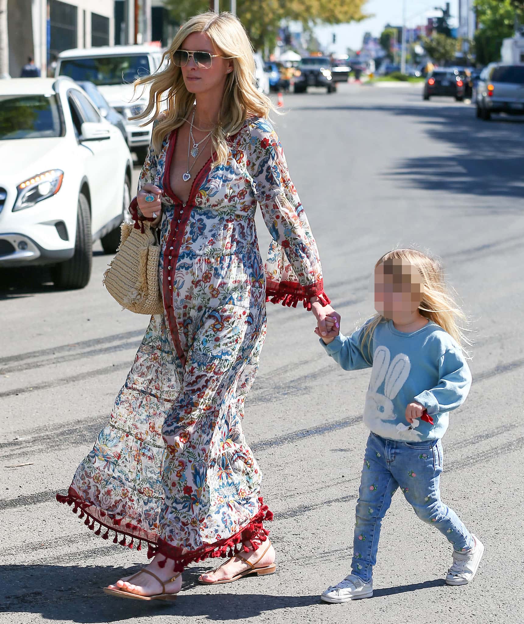 Pregnant Nicky Hilton steps out in Los Angeles with daughter Teddy on February 24, 2022, pairing an Alice + Olivia floral maxi dress with minimalist Canfora Gail flat sandals and a woven raffia tote for an effortlessly polished maternity look