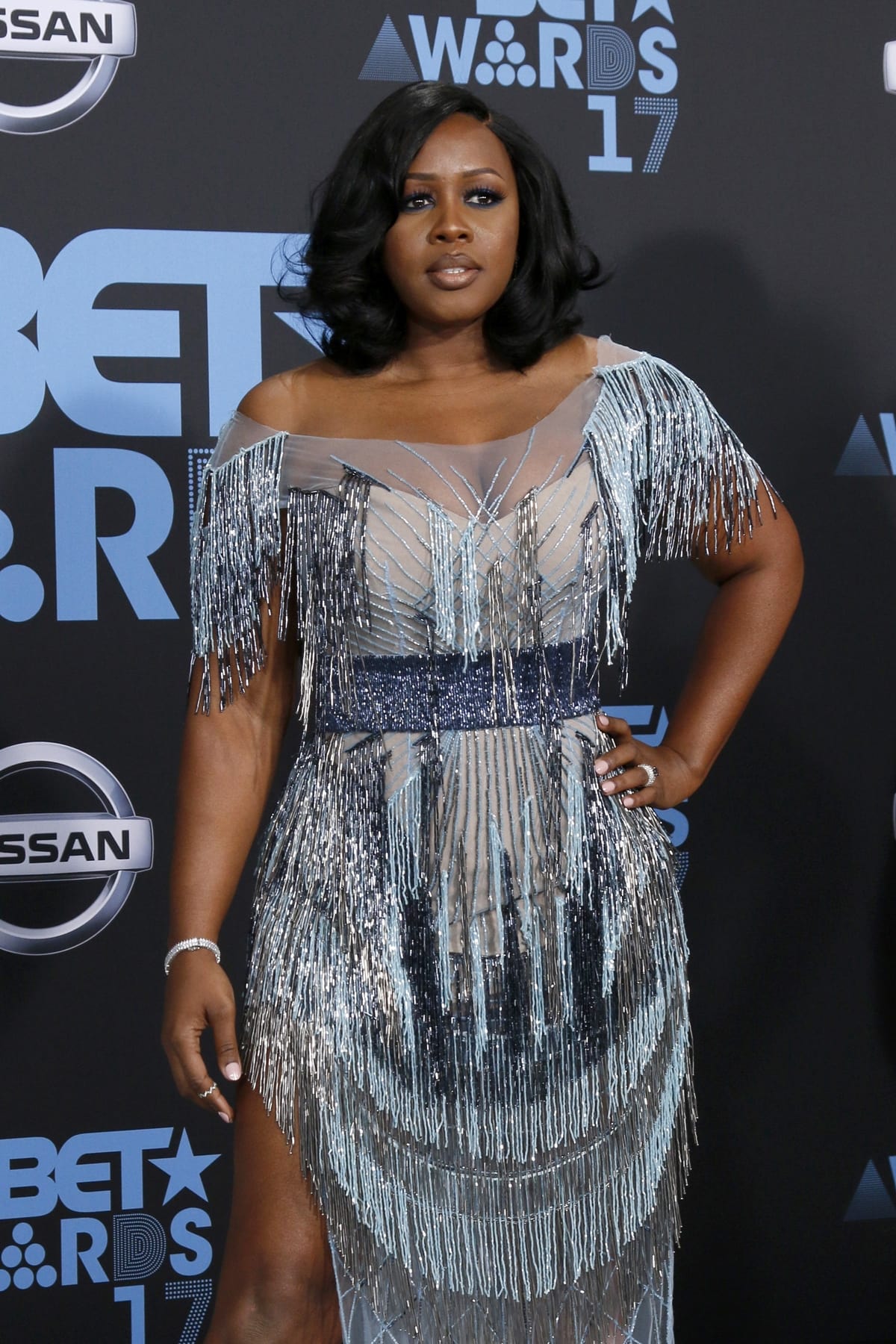 Remy Ma dazzled at the 2017 BET Awards in a shimmering off-the-shoulder dress adorned with cascading silver fringe and a glittering waistband, adding retro-glam flair to her red carpet appearance