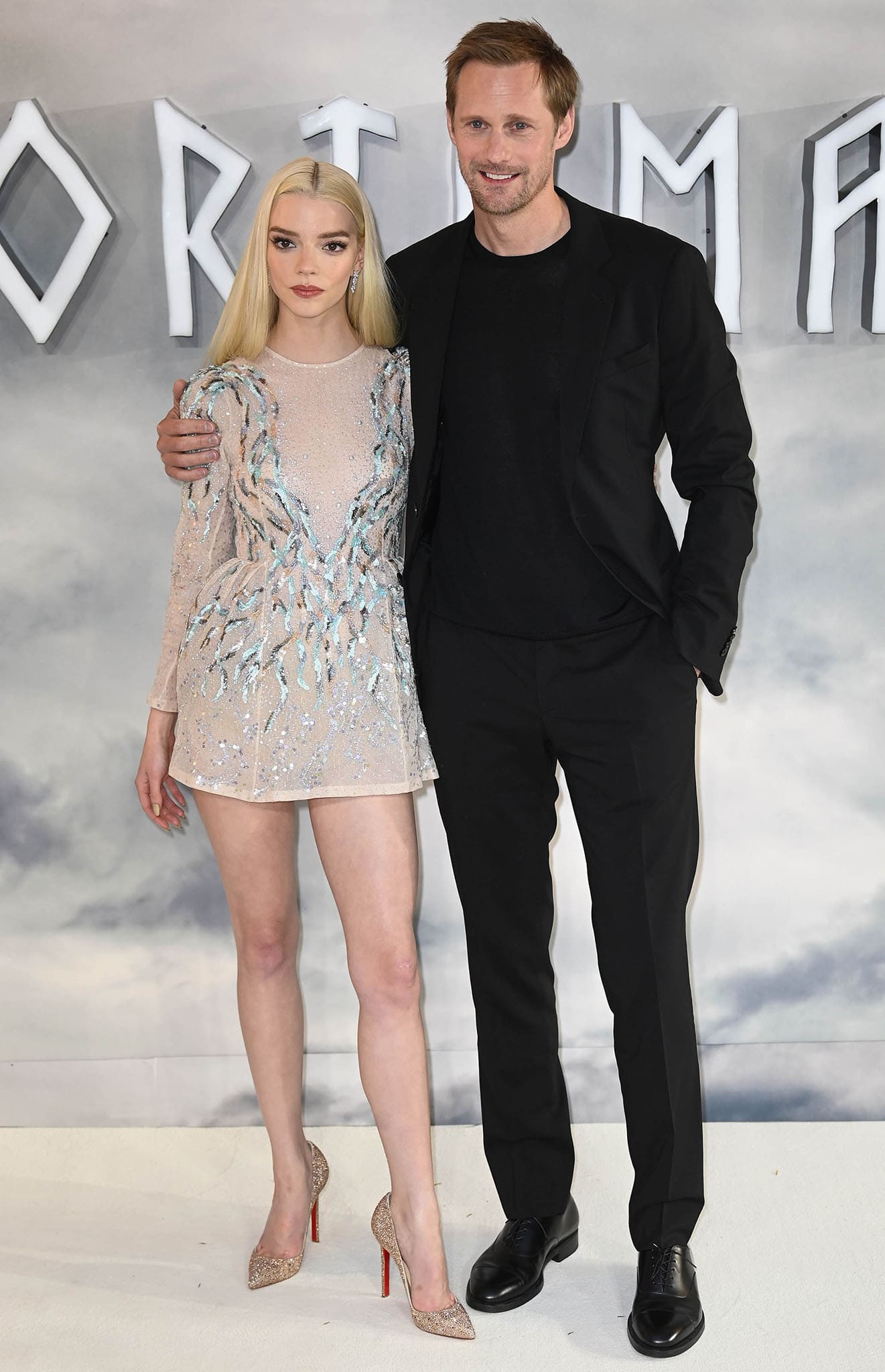 Anya Taylor-Joy, standing 5'6½" in sky-high crystal Louboutin pumps, contrasts strikingly with 6'4" Alexander Skarsgård as the pair pose in shimmering Dior and sleek all-black tailoring at The Northman London premiere on April 5, 2022