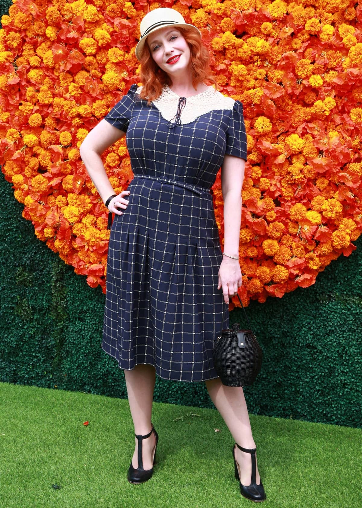 Christina Hendricks exudes vintage charm in a blue plaid Ralph Lauren dress, paired with classic T-strap heels and a chic hat at the Veuve Clicquot Polo Classic